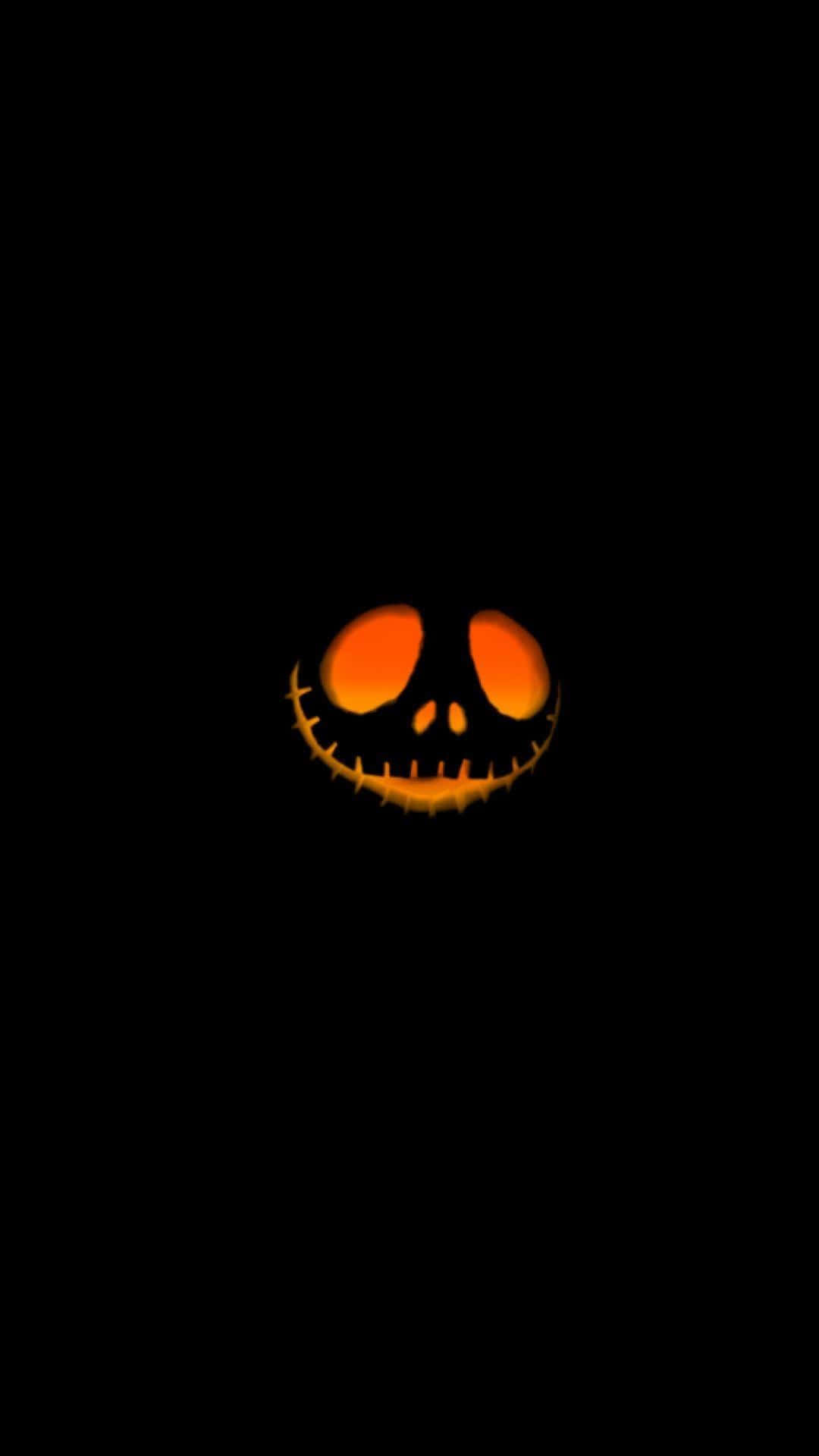 Orange Halloween 桌布 壁紙 — 一個發光的傑克南瓜燈臉孔，帶有縫合的笑容和橙色眼睛，在漆黑的背景中閃耀。
