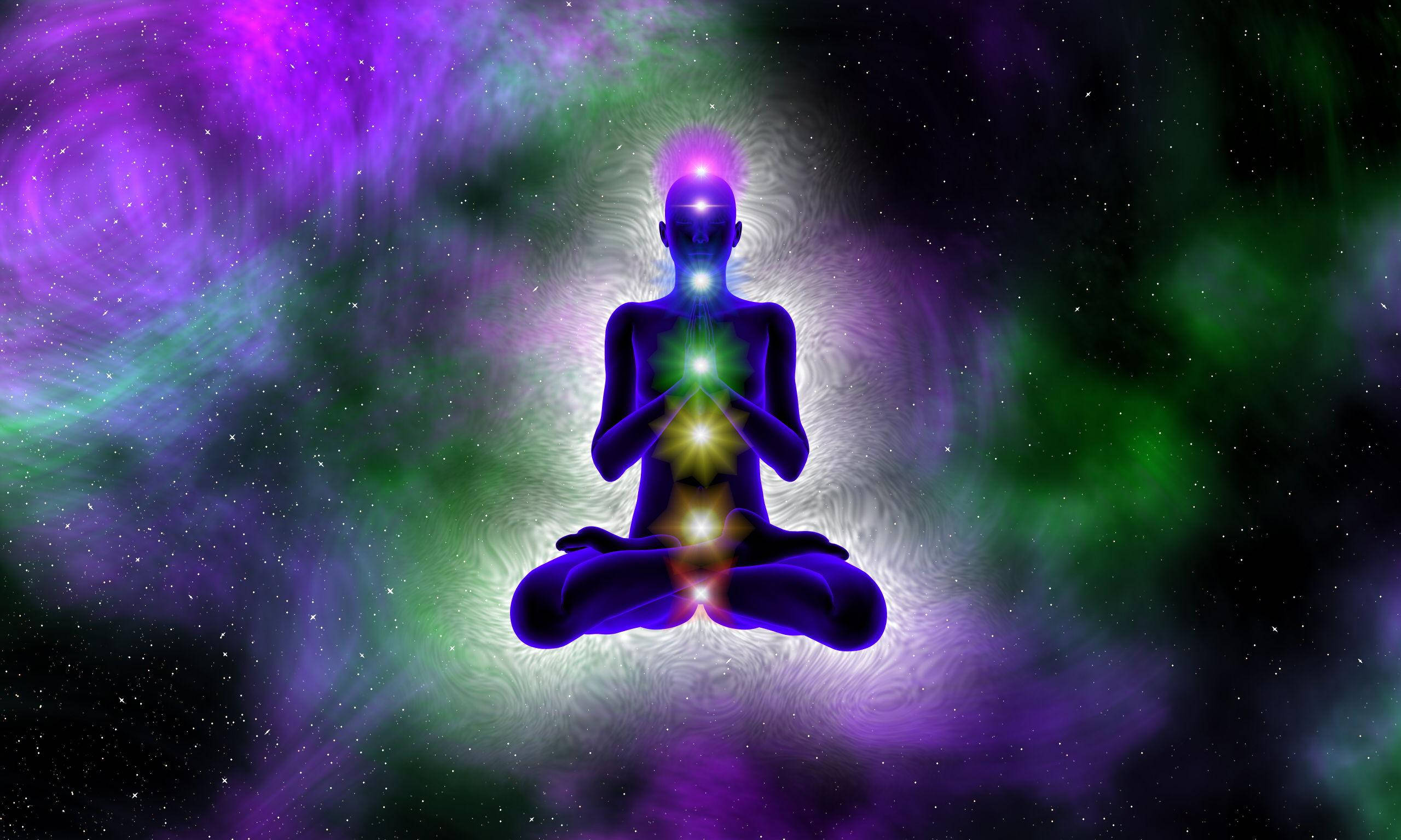 靈性動圖 桌布 壁紙 — 一個發光的剪影在宇宙空間中冥想，周圍環繞著充滿活力的紫色和綠色星雲。