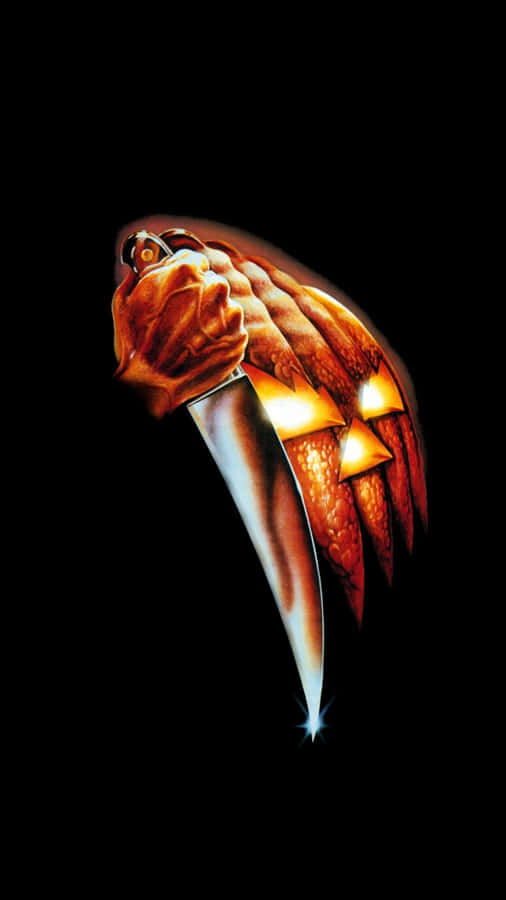 Aesthetic iPhone Horror 桌布 壁紙 — 一個發光的南瓜燈，帶有兇惡的雕刻面孔，在黑色背景上握著一把閃閃發光的刀。