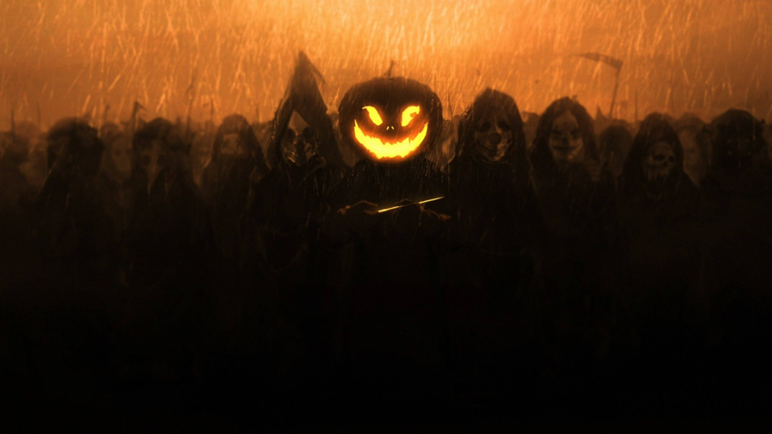 Spooky Aesthetic 桌布 壁紙 — 一個發光的南瓜燈引領一群戴著兜帽的威脅人群，在雨水浸濕、火熱橙色的噩夢中。