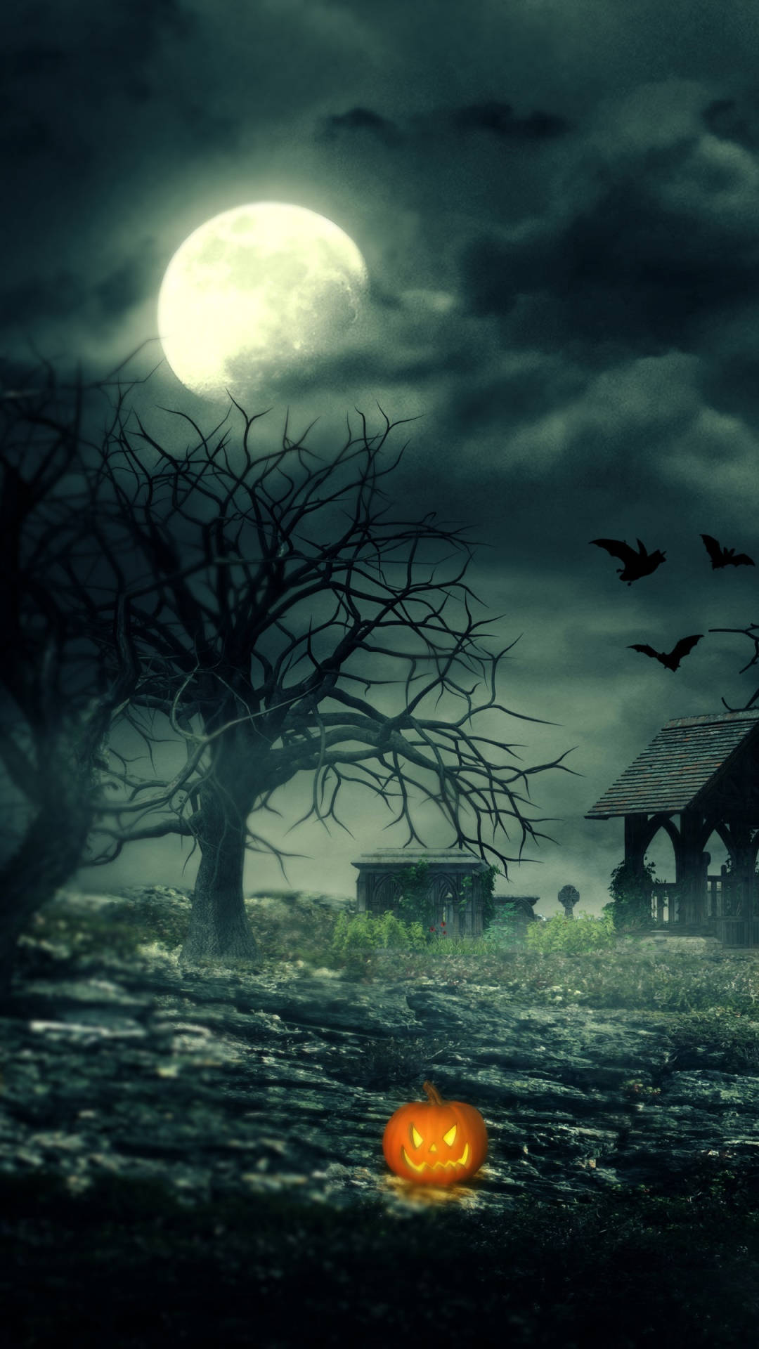 Halloween Phone 桌布 壁紙 — 一個發光的南瓜燈籠放在霧氣瀰漫的墓園中，滿月下蝙蝠在光禿的樹木附近飛翔。