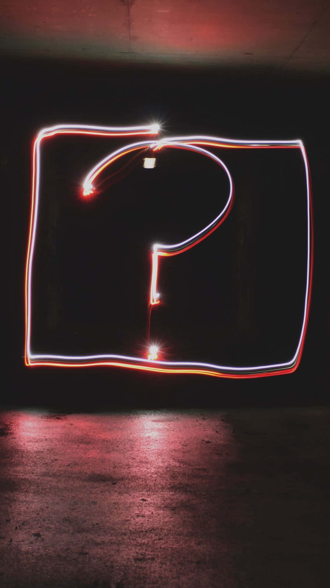 Question Mark 桌布 壁紙 — 一個發光的問號，以光跡繪畫在深色混凝土牆上，帶有紅色地板反射。
