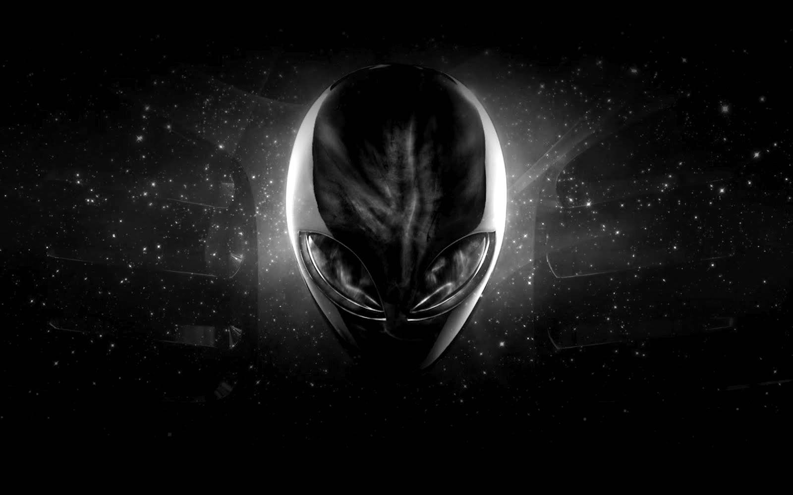 Cool Alien 桌布 壁紙 — 一個發光的外星人頭部，有大眼睛，在黑暗背景的星空宇宙虛空中漂浮。