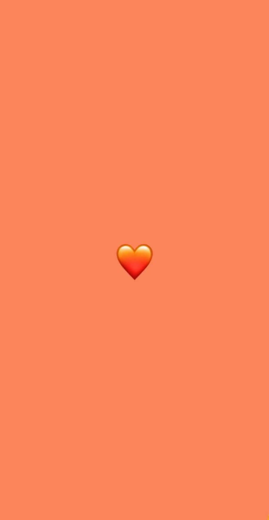 Orange Heart 桌布 壁紙 — 一個發光的心形表情符號居中在純珊瑚色背景上。