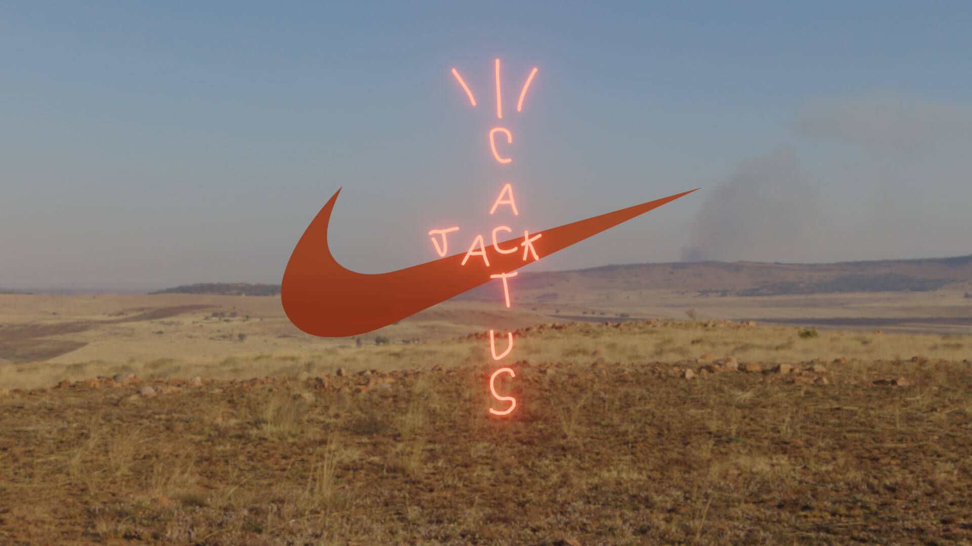 仙人掌傑克 桌布 壁紙 — 一個發光的橙色Nike勾勾和「Cactus Jack」霓虹燈牌漂浮在乾燥的草地上，背景是清澈的藍天。