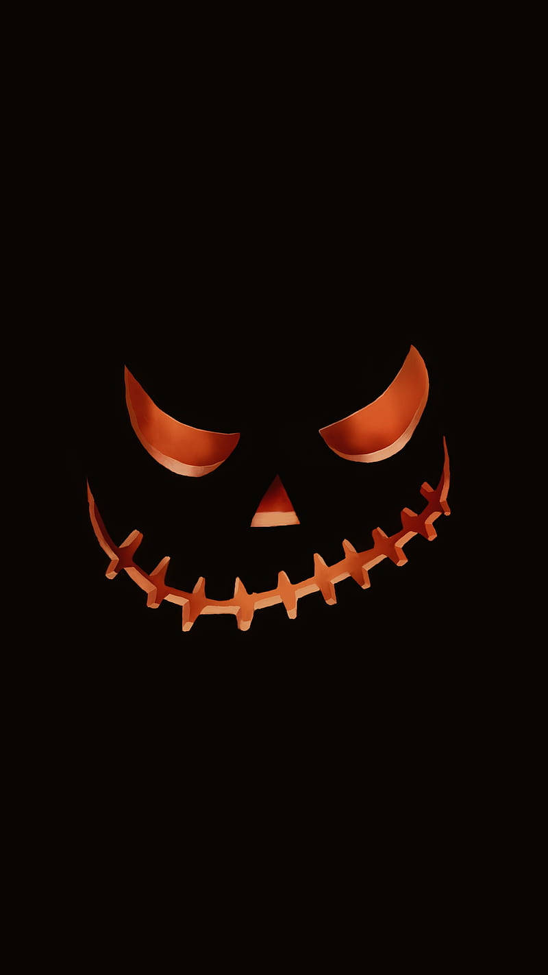 Halloween Phone 桌布 壁紙 — 一個發光的橙色傑克南瓜燈臉，帶有縫合的笑容和威脅性的眼睛，背景為黑色。