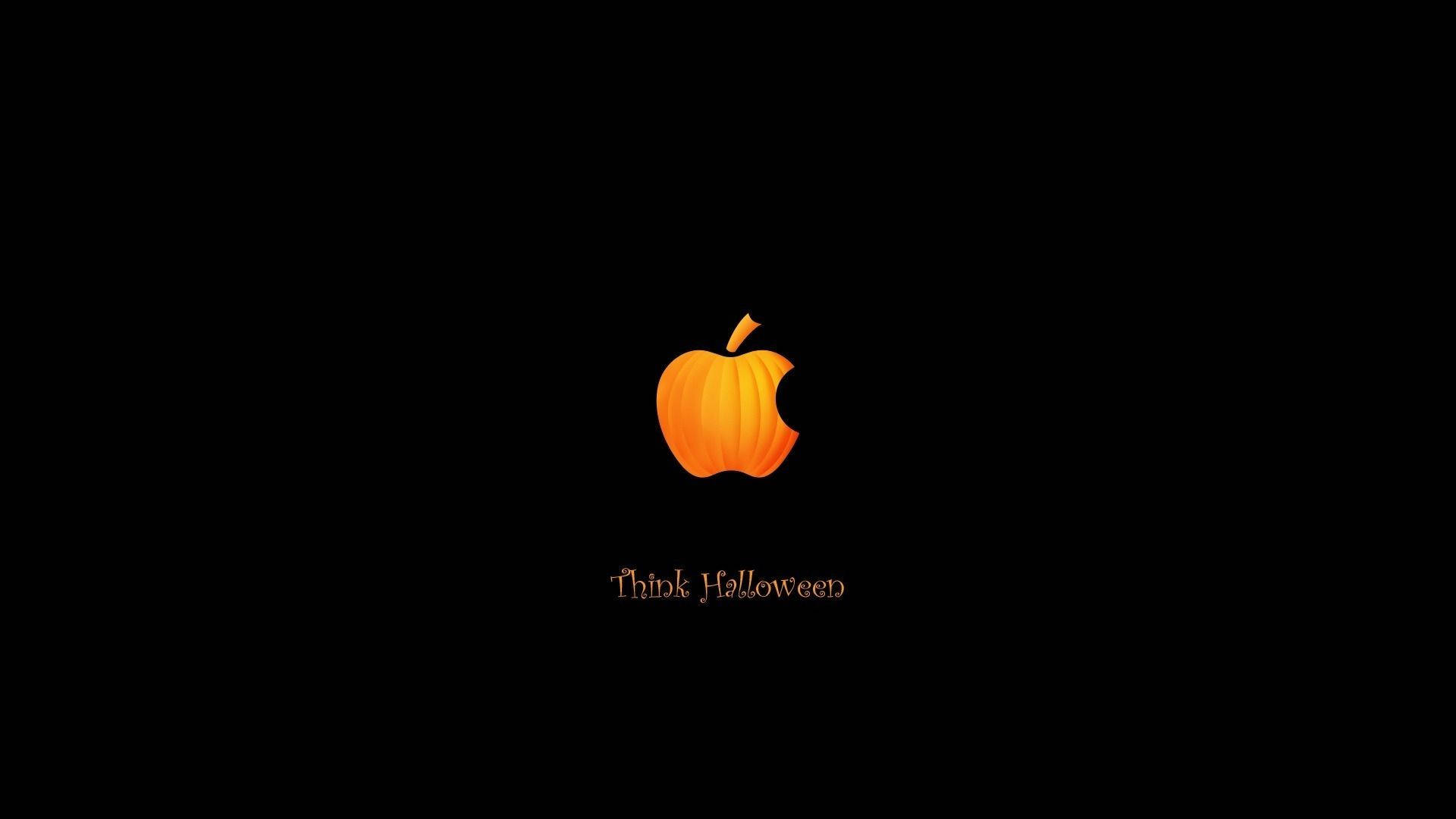 Cute Aesthetic Halloween 桌布 壁紙 — 一個發光的橙色南瓜Apple標誌，帶有咬痕，居中在黑色背景上，下方有'Think Halloween'文字。