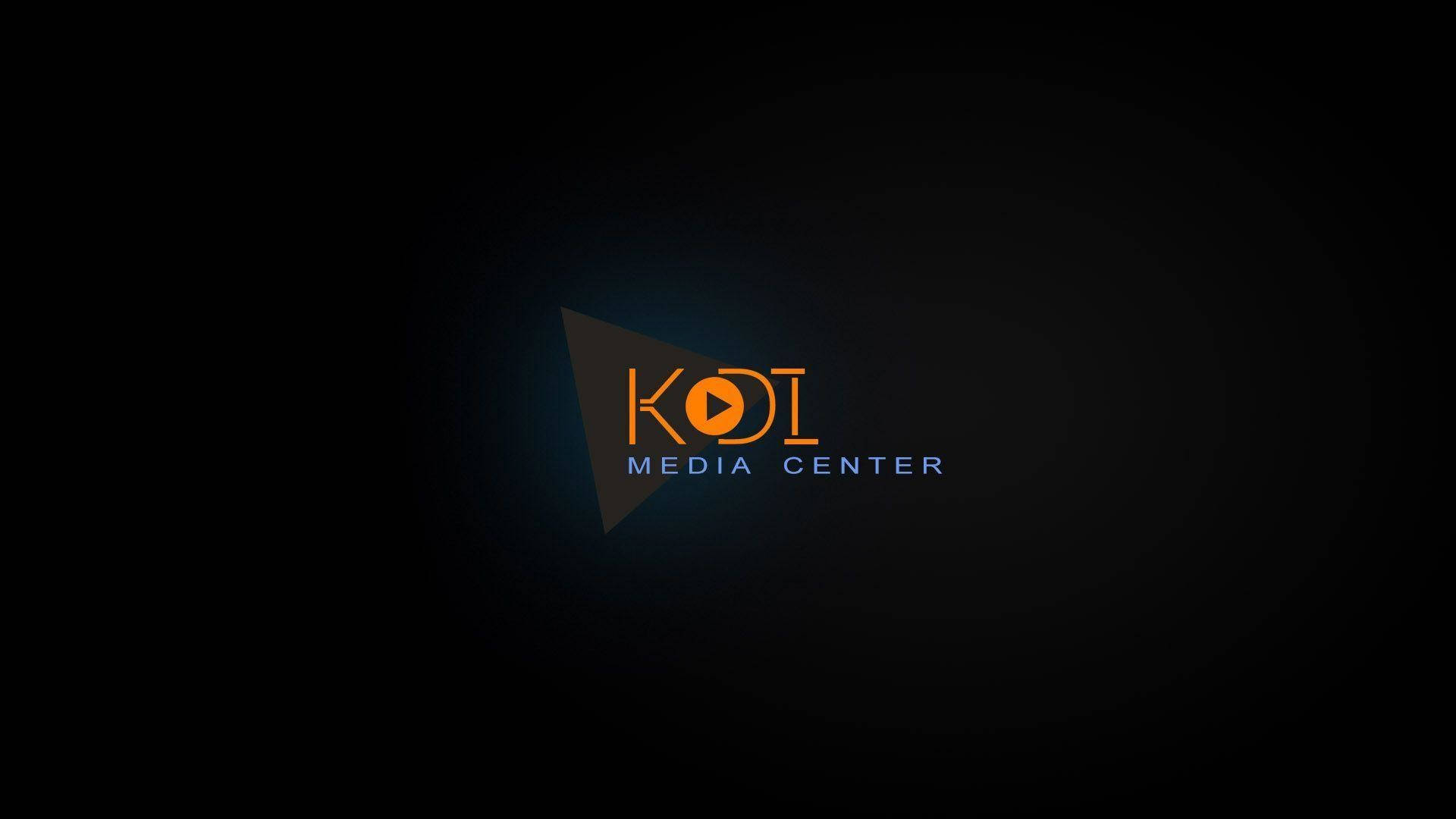 Kodi 桌布 壁紙 — 一個發光的橙色和藍色「KOI MEDIA CENTER」標誌，居中放置在帶有柔和光線的深色漸變背景上。