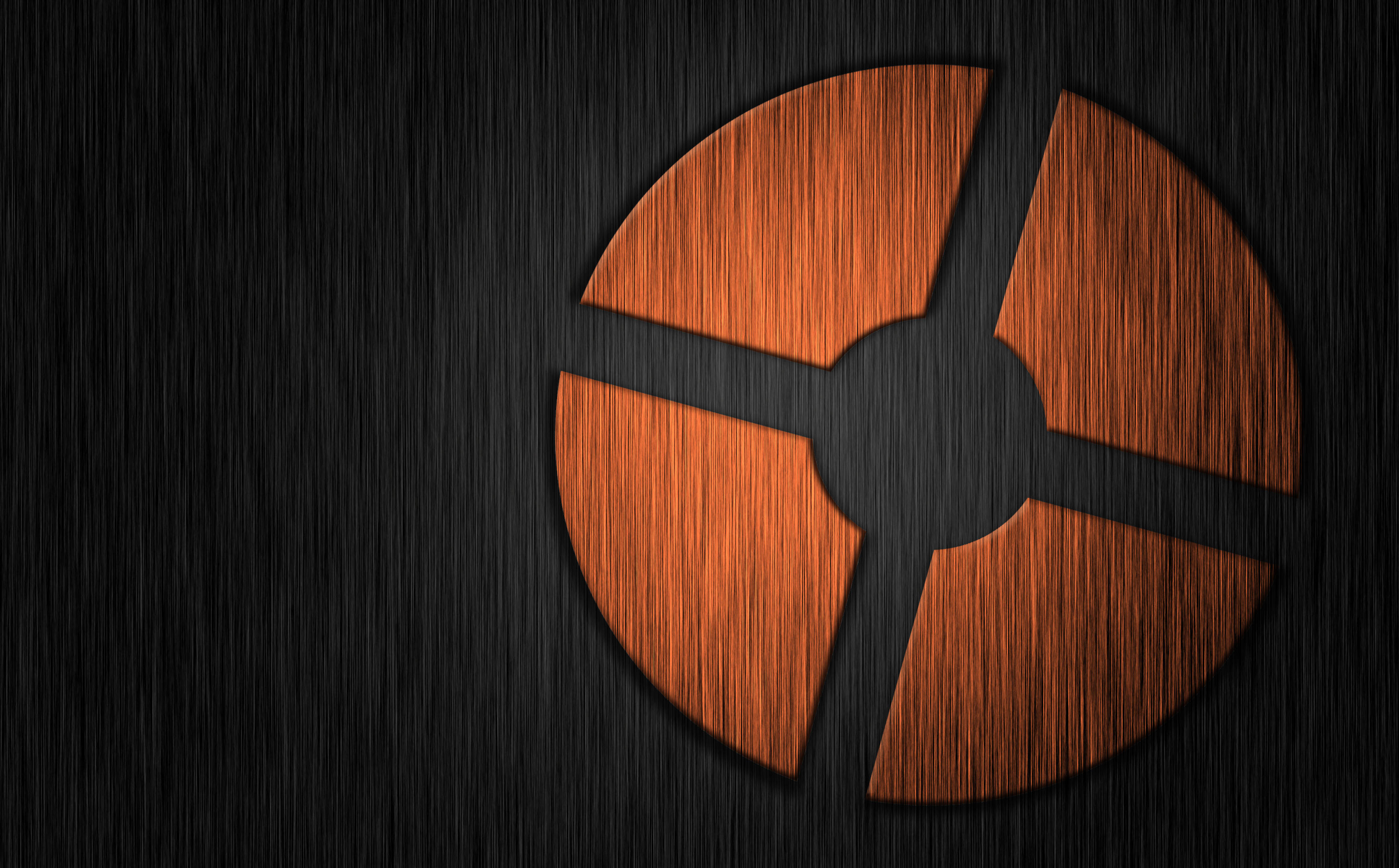 Tf2 Logo 桌布 壁紙 — 一個發光的橙色圓形徽章，帶有四個葉片，置於深色拉絲金屬背景上。