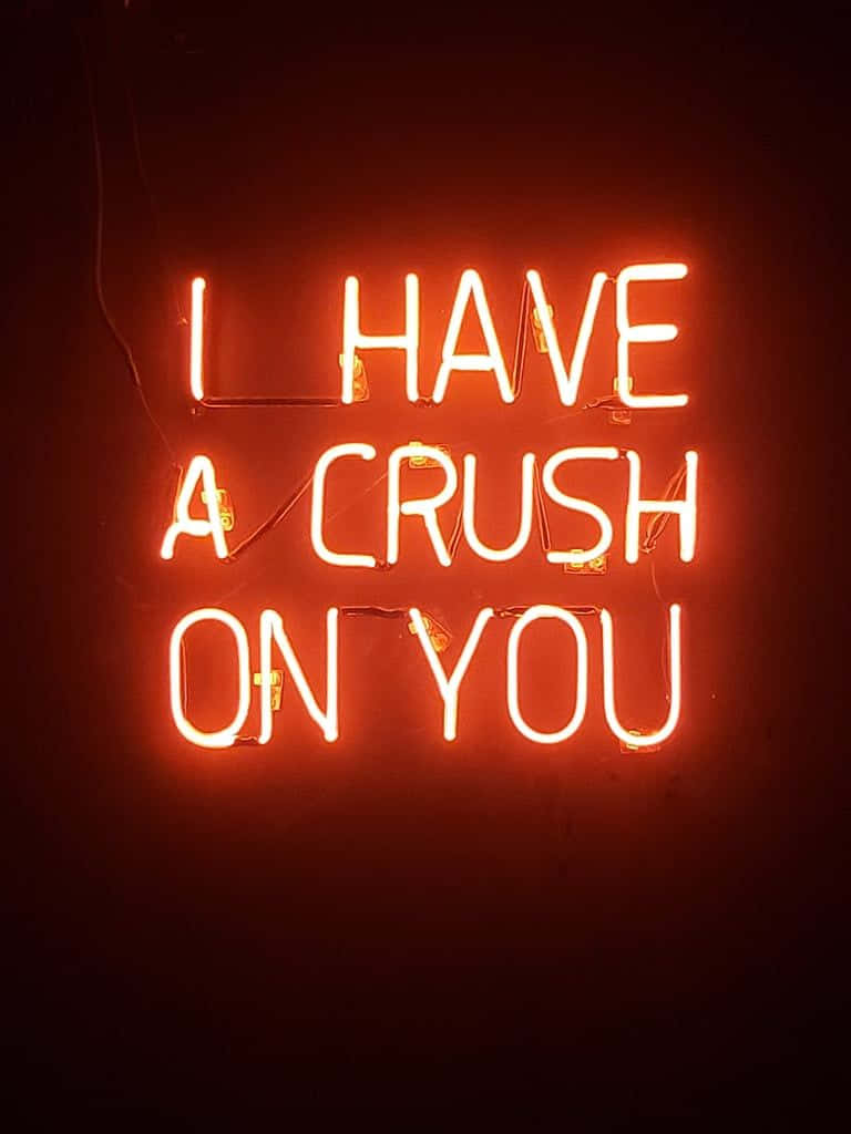 鎖屏 桌布 壁紙 — 一個發光的橙色霓虹燈牌，上面寫著「I HAVE A CRUSH ON YOU」，背景是深色牆壁。