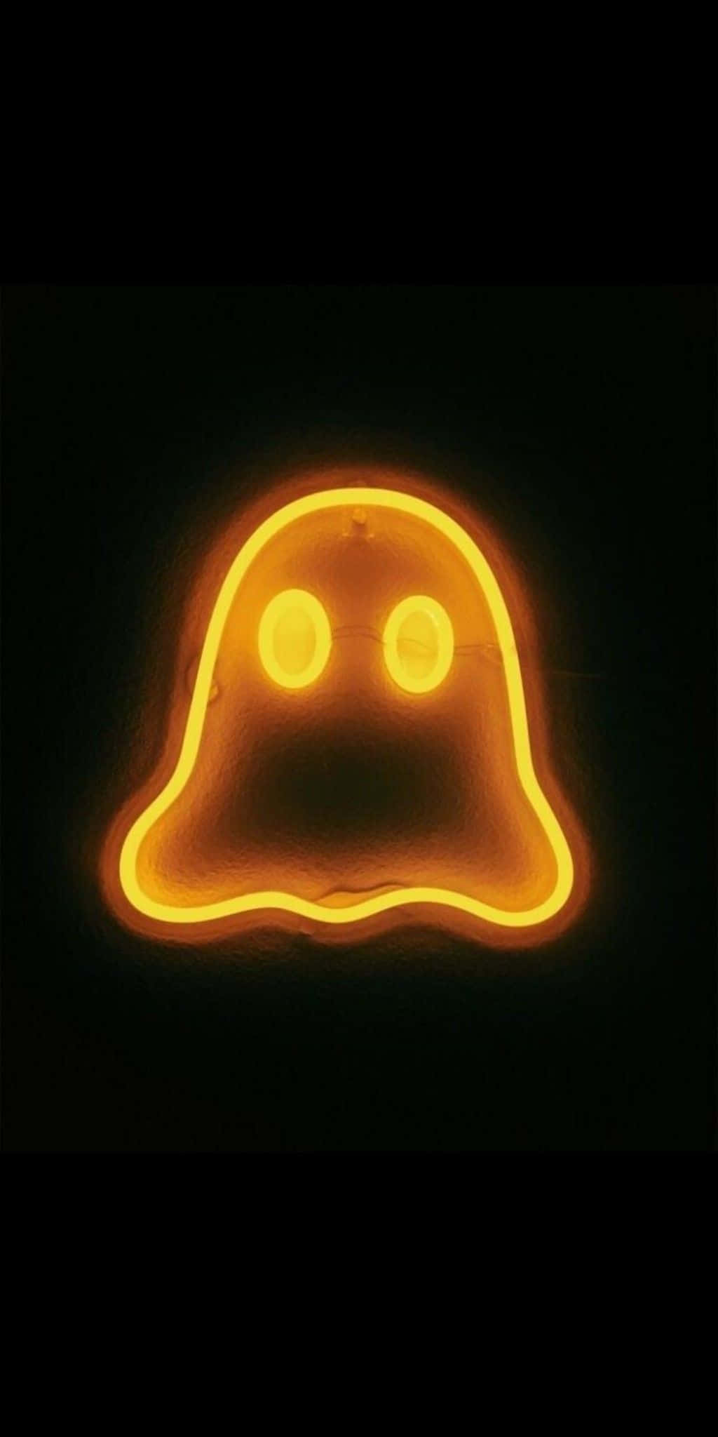 Neon Halloween 桌布 壁紙 — 一個發光的橙色霓虹鬼魂標誌，帶有圓圓的眼睛，在漆黑的背景下明亮地閃耀。
