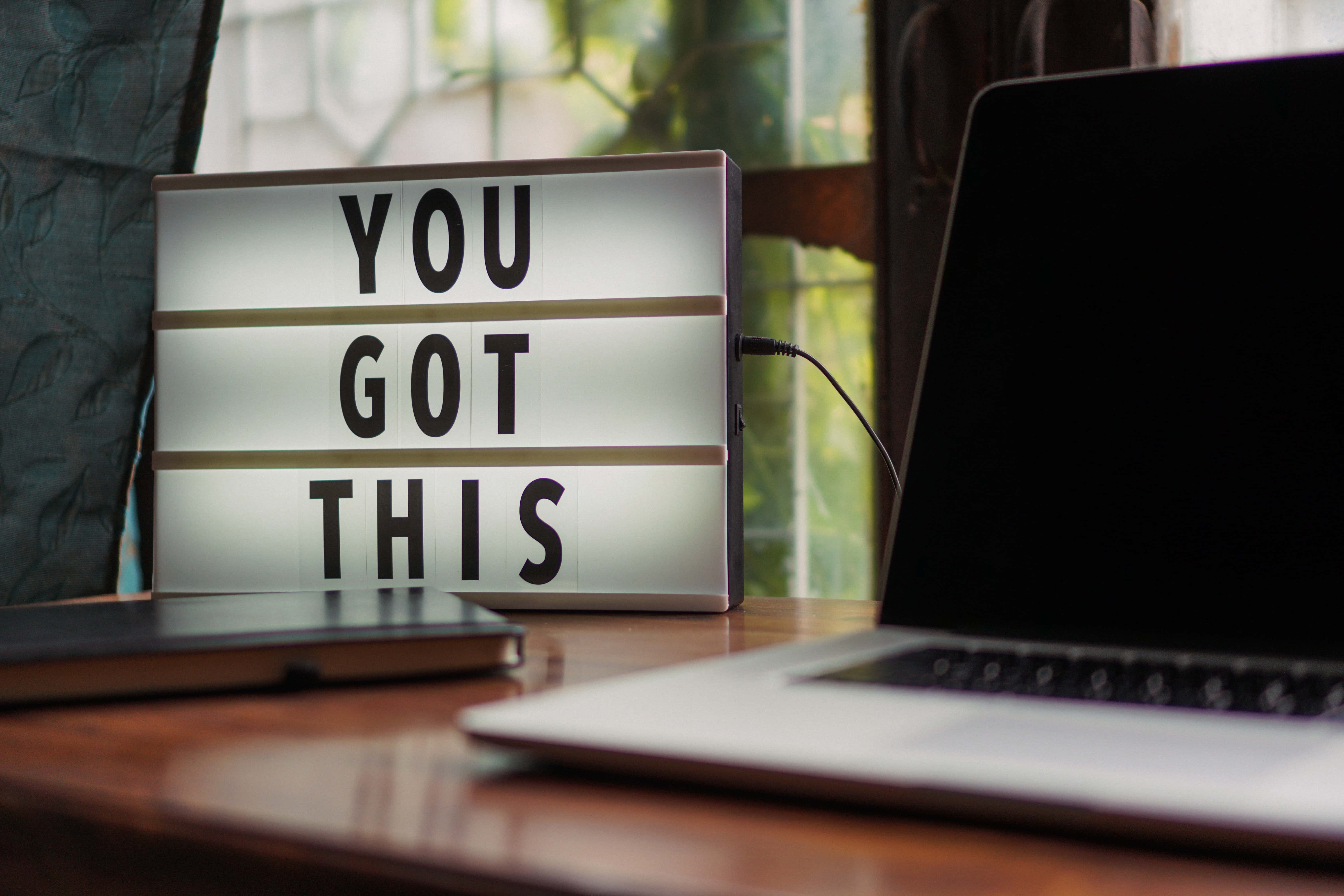 Good Quotes 桌布 壁紙 — 一個發光的燈箱顯示「YOU GOT THIS」，放在窗邊木桌上，旁邊有一台筆記型電腦。
