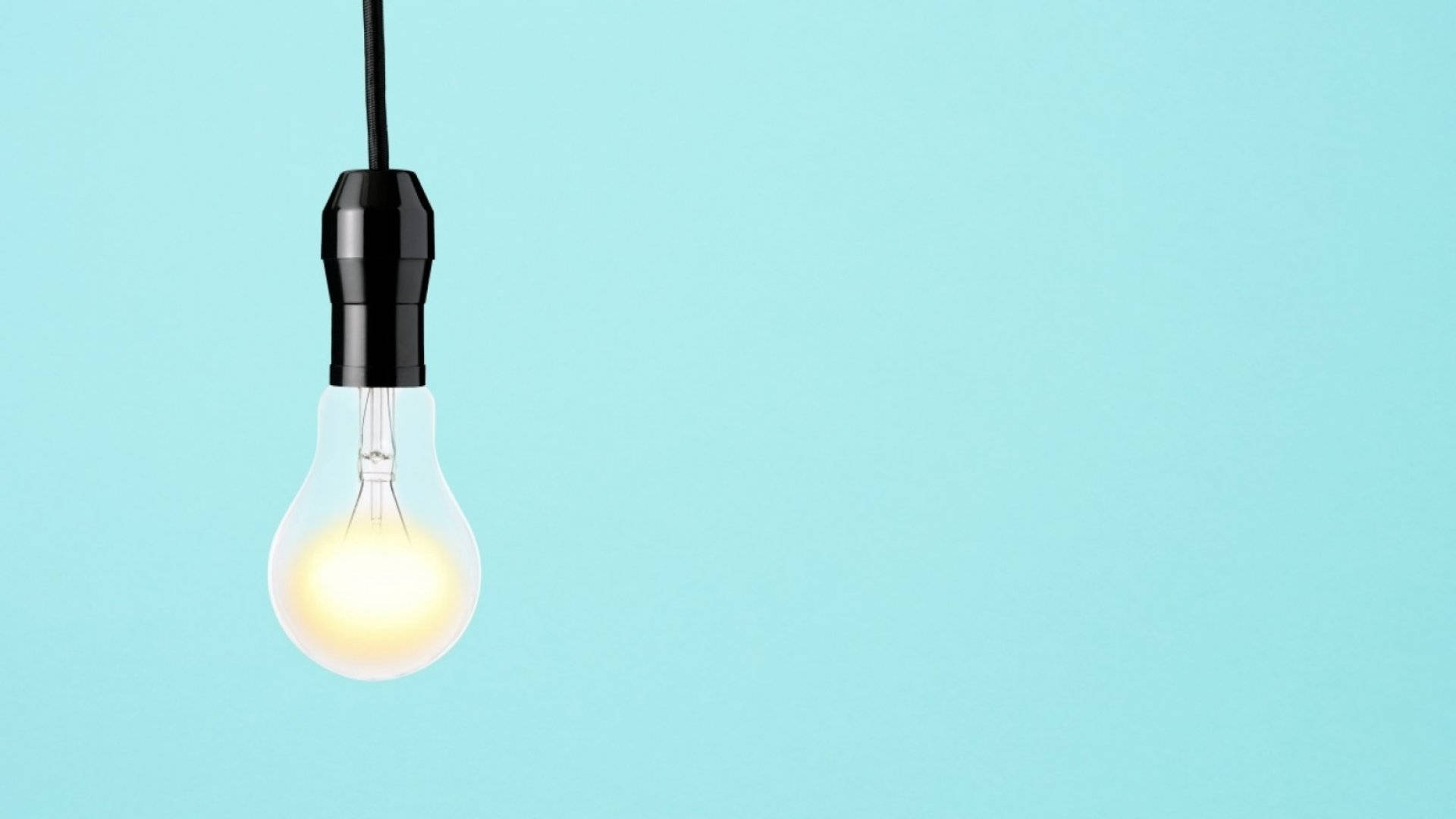 Idea 桌布 壁紙 — 一個發光的白熾燈泡懸掛在純淺藍色背景上。