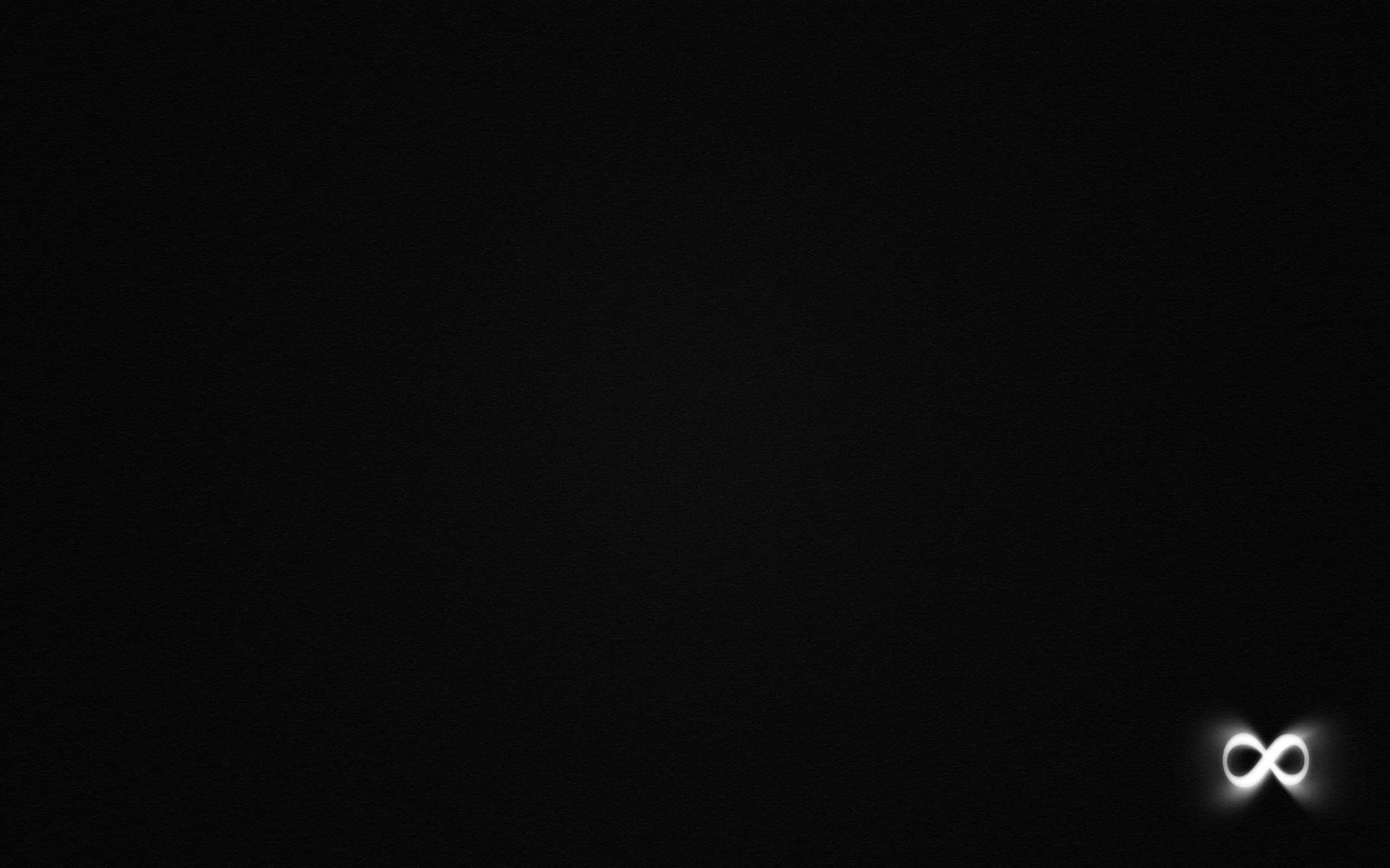Dark Infinity 桌布 壁紙 — 一個發光的白色無限符號漂浮在深邃的黑色空間中，在虛無的背景上散發出柔和的光芒。