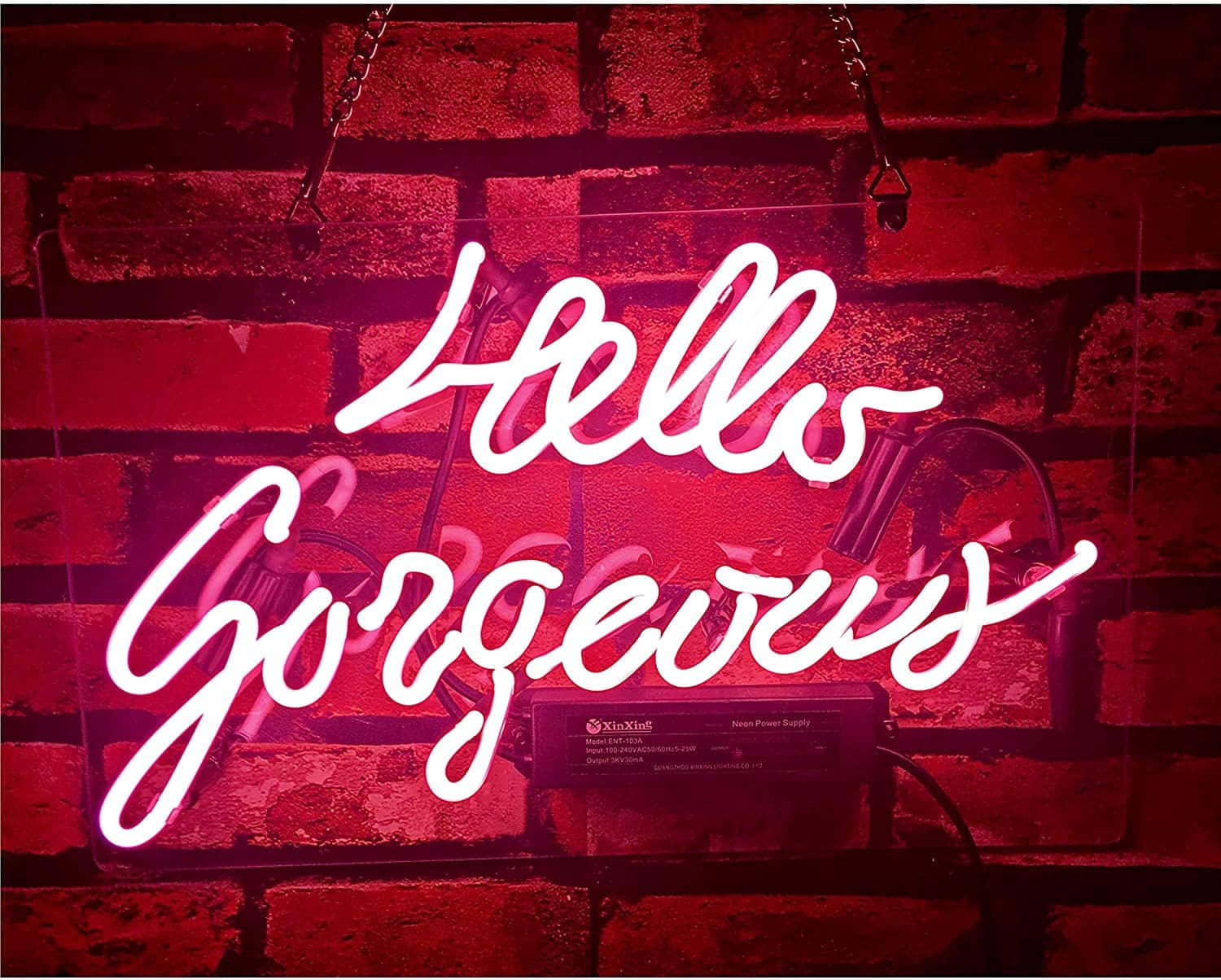 neon sign 桌布 壁紙 — 一個發光的白色霓虹燈牌，上面寫著「Hello Gorgeous」，在紋理磚牆上投射出溫暖的紅色光芒。