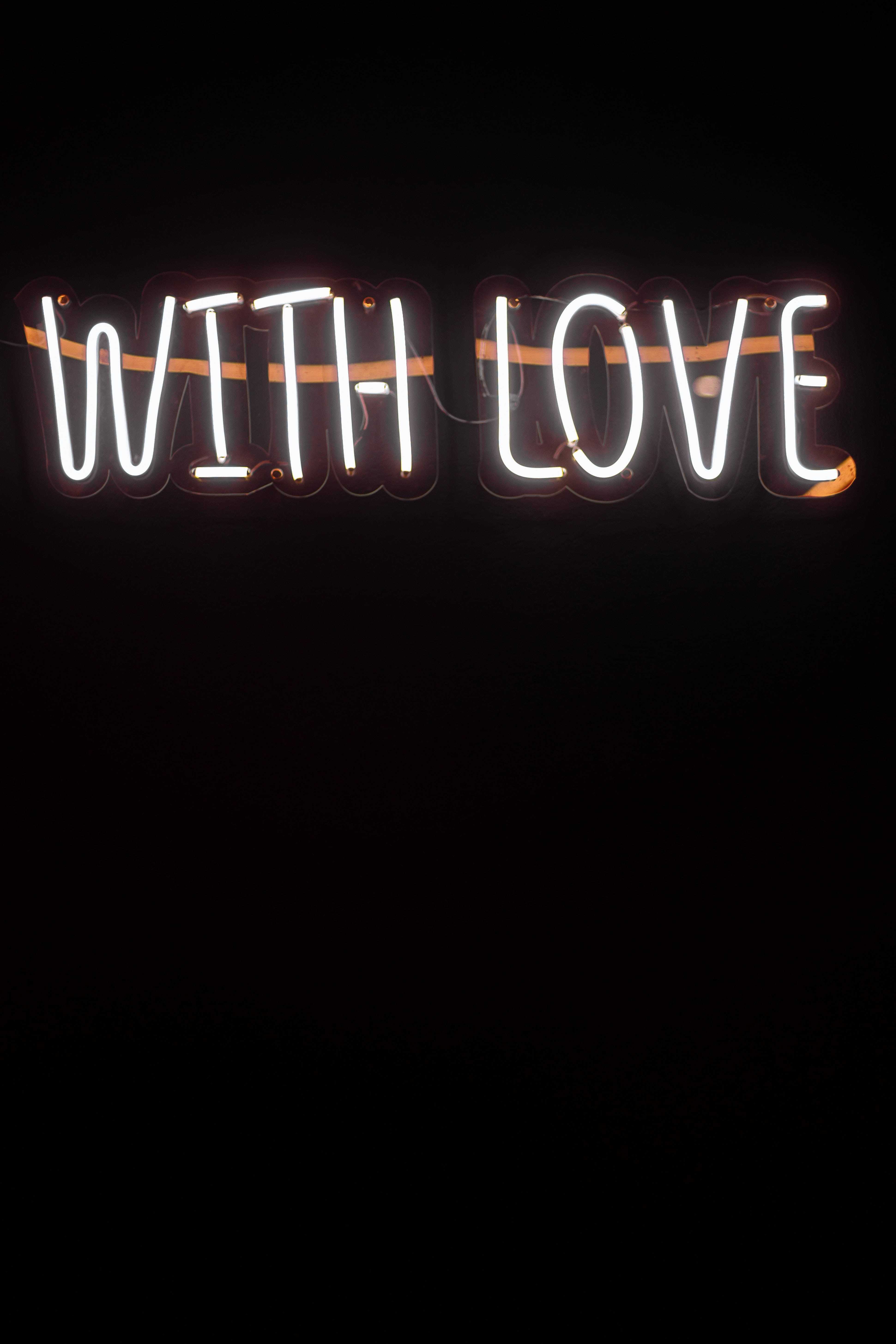 愛心 桌布 壁紙 — 一個發光的白色霓虹燈牌，上面寫著「WITH LOVE」，背景是漆黑的。