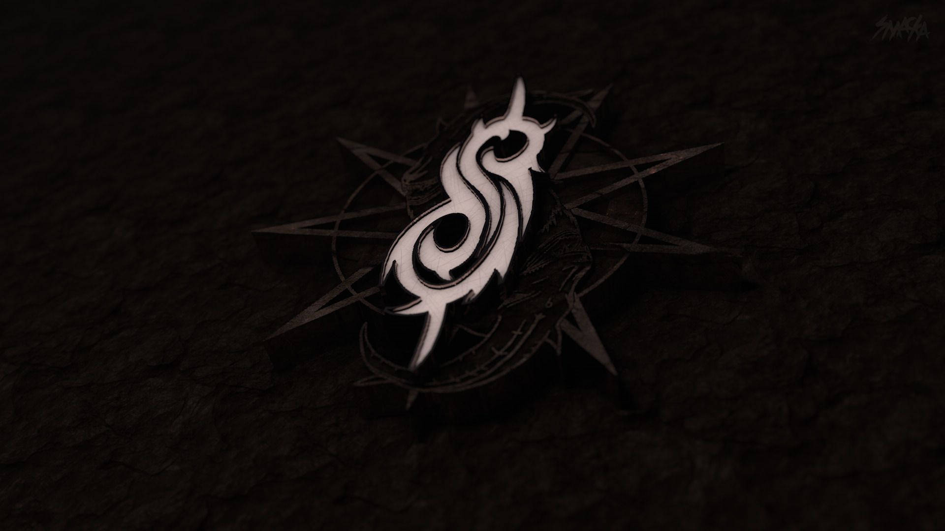 Slipknot 桌布 壁紙 — 一個發光的白色風格化S符號帶有角，放置在黑暗紋理表面的指南針玫瑰上。