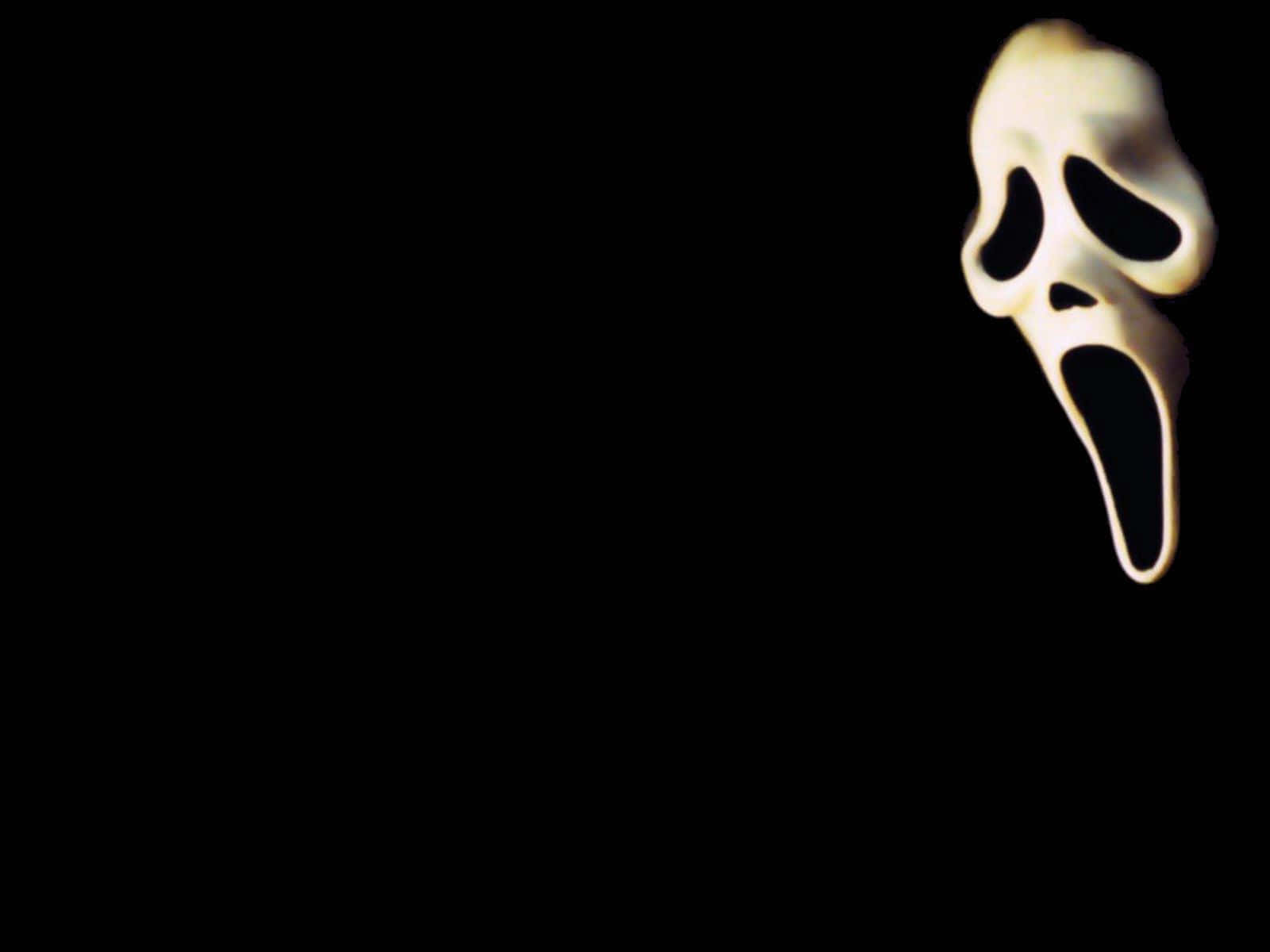 吶喊 桌布 壁紙 — 一個發光的白色鬼面具，帶有尖叫的表情，漂浮在純黑色背景上。
