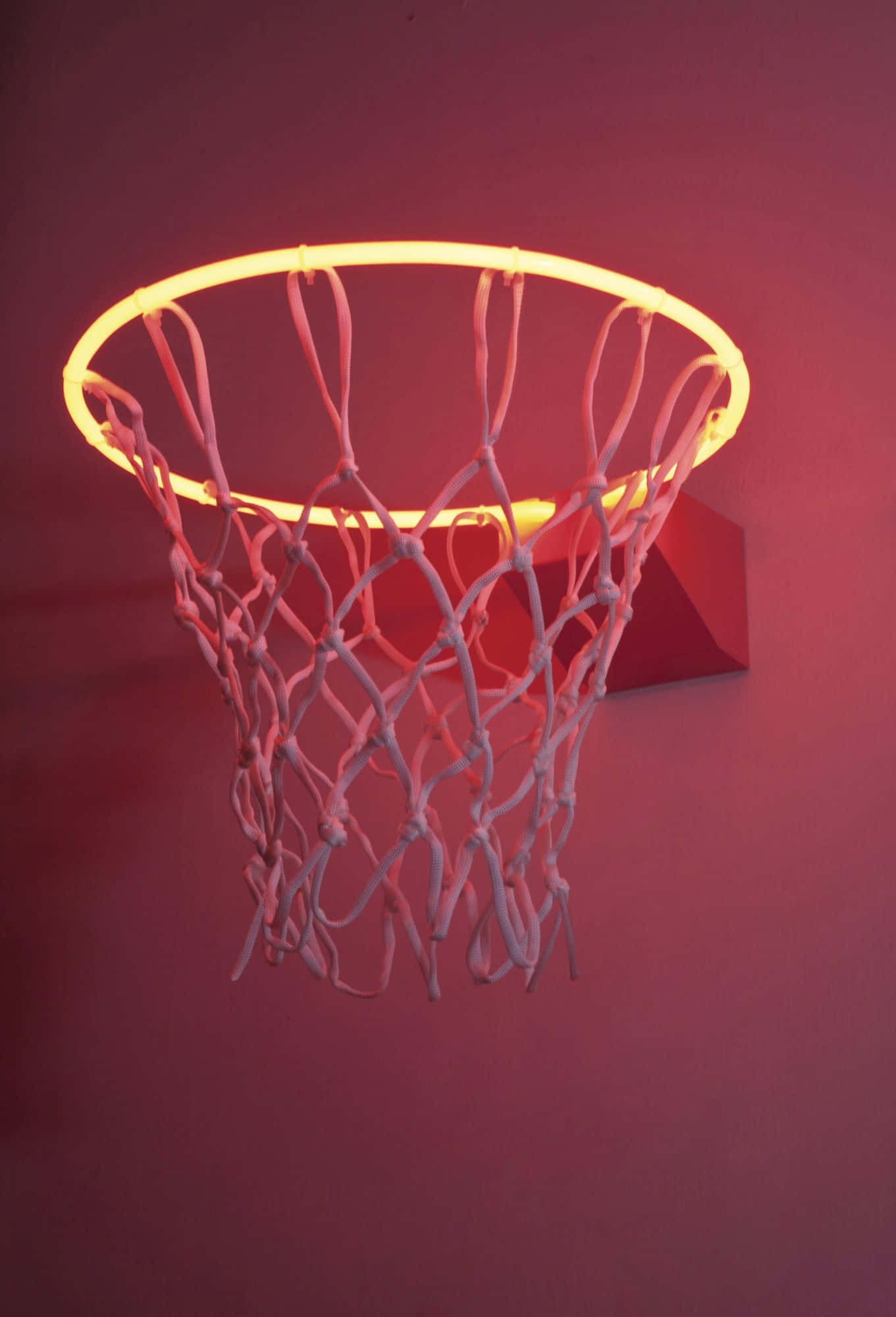 Basketball Aesthetic 桌布 壁紙 — 一個發光的籃球框，帶有霓虹燈邊框和白色網，安裝在深紅色牆壁上。