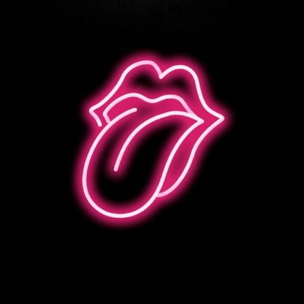 Tongue Out 桌布 壁紙 — 一個發光的粉紅色霓虹燈標誌，顯示一條伸出的舌頭，背景為黑色。