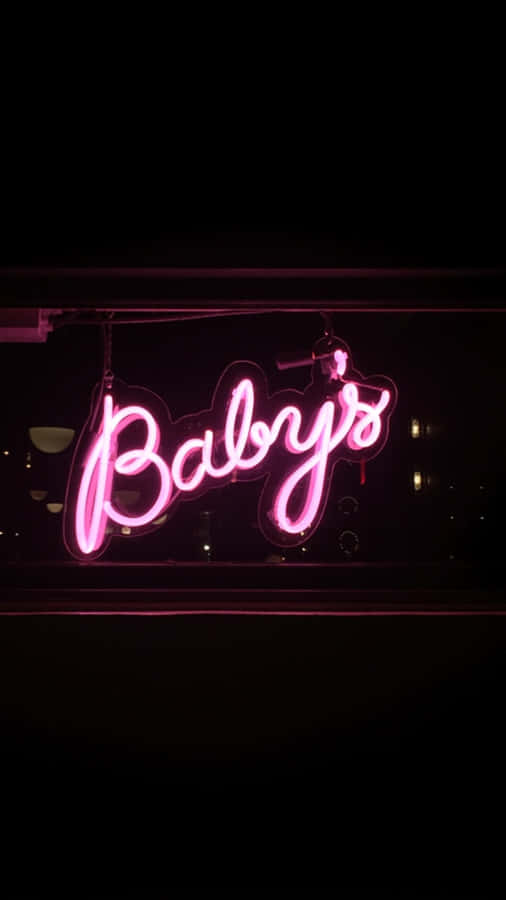 Neon Lights Aesthetic 桌布 壁紙 — 一個發光的粉紅色霓虹燈牌，上面寫著 'Baby's'，在漆黑的夜晚背景下明亮地閃耀。