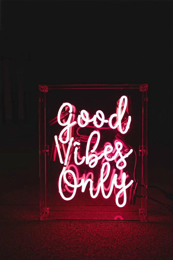粉紅色霓虹燈牌，在黑暗房間中以草書文字顯示 Good Vibes Only。 — 深色引言 壁紙