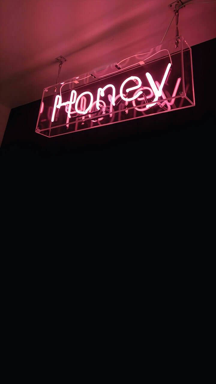 small quotes 桌布 壁紙 — 一個發光的粉紅色霓虹燈牌，拼寫著 honey，懸掛在黑暗的房間中，散發出柔和的環境光。