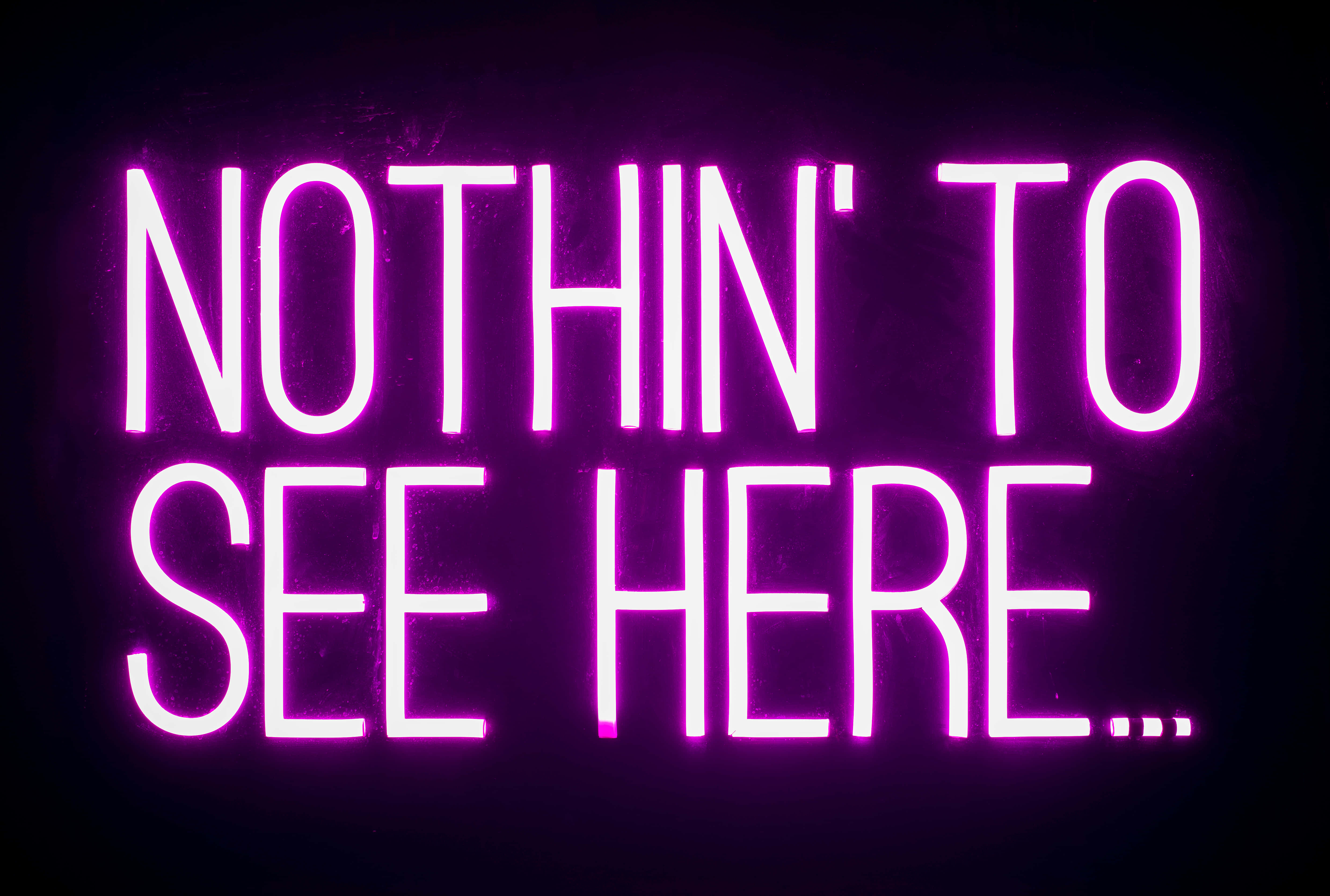 Neon Lights Aesthetic 桌布 壁紙 — 一個發光的粉紅色霓虹燈牌在黑暗背景上顯示「NOTHIN' TO SEE HERE...」。