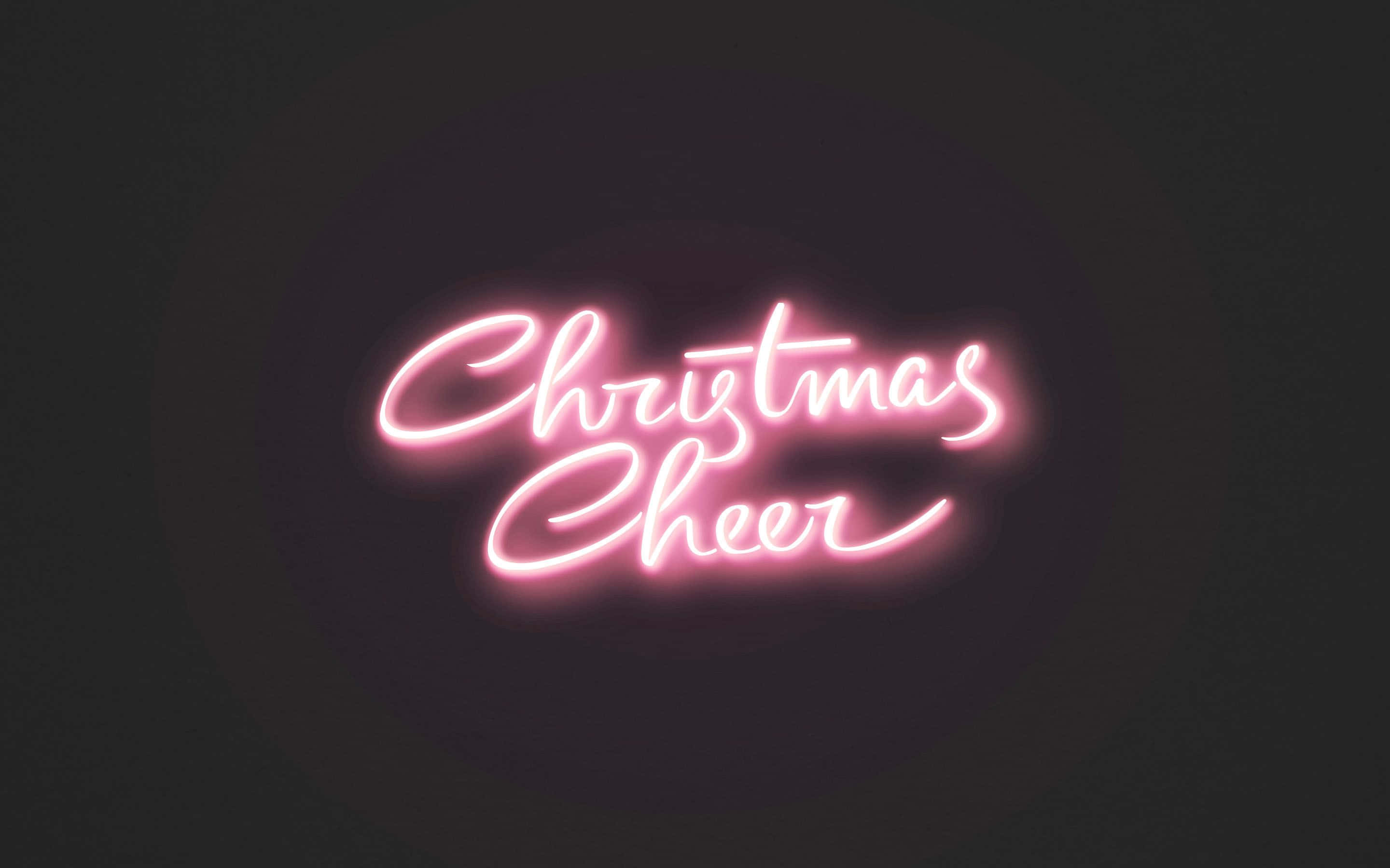 美學 桌布 壁紙 — 一個發光的粉紅色霓虹燈牌顯示Christmas Cheer，背景為深色，帶有柔和的光暈。