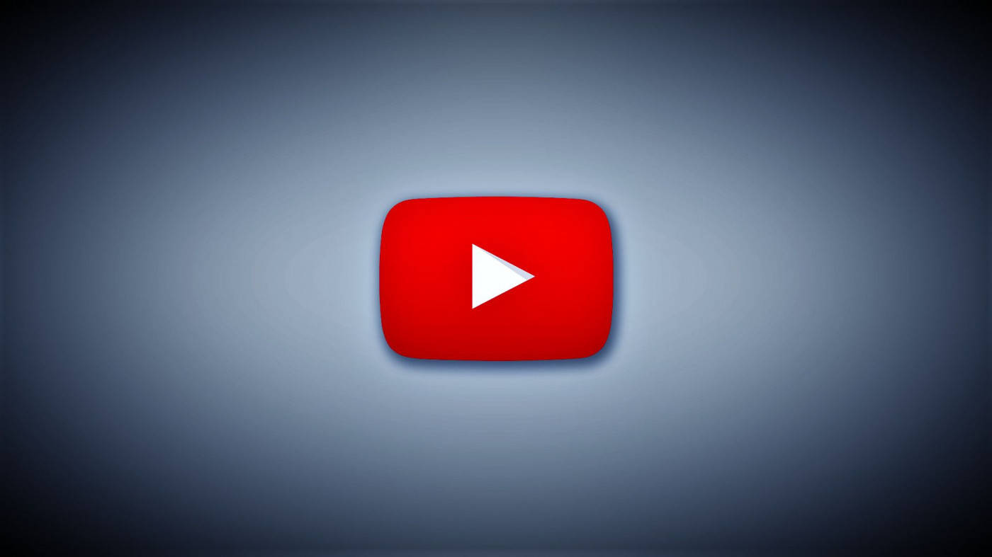 YouTube Logo 桌布 壁紙 — 一個發光的紅色 YouTube 播放按鈕，居中於帶有柔和照明的漸變灰色背景上。