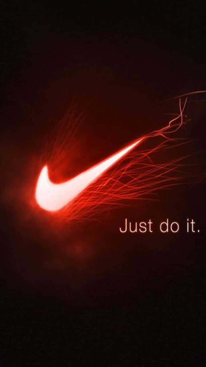 Red Led 桌布 壁紙 — 一個發光的紅色Nike勾號在黑暗背景上散發能量，並帶有口號「Just do it。」