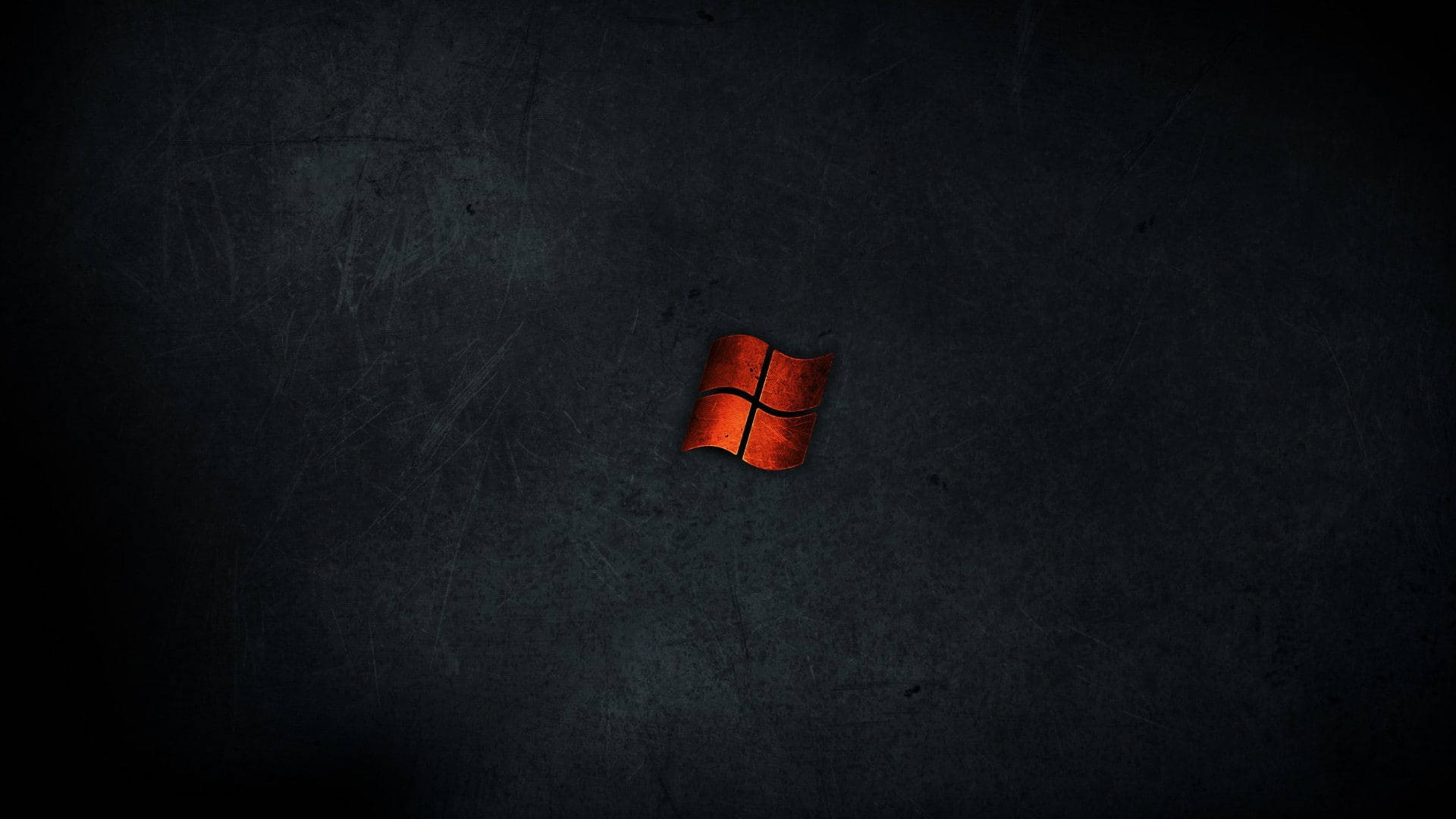 黑色 Windows 10 桌布 壁紙 — 一個發光的紅色Windows標誌，居中在黑暗的刮痕金屬表面上，帶有戲劇性的燈光。