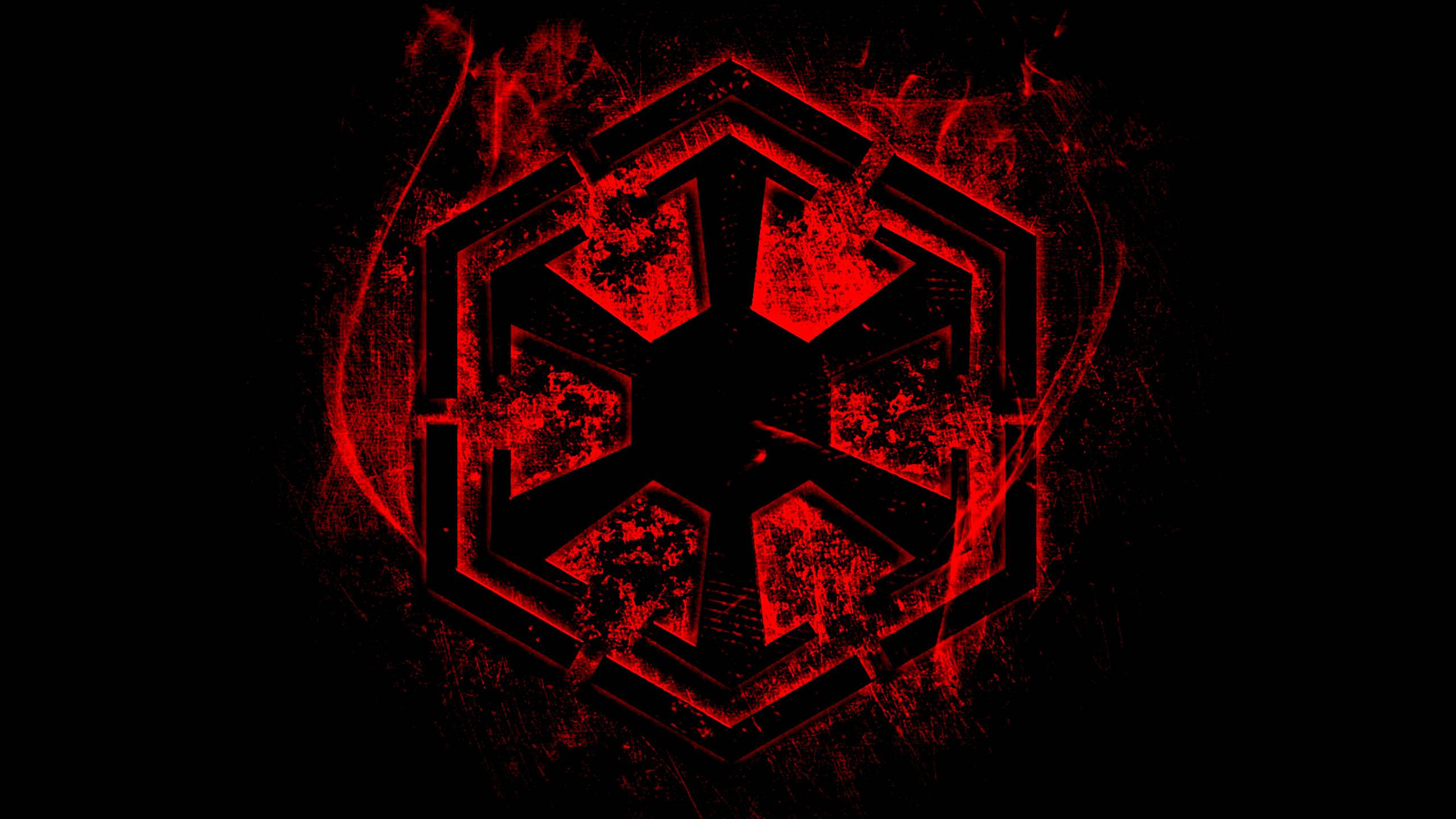 Red Star 桌布 壁紙 — 一個發光的紅色六邊形徽章，帶有星爆設計，在帶有煙霧紋理的黑色背景上放射光芒。