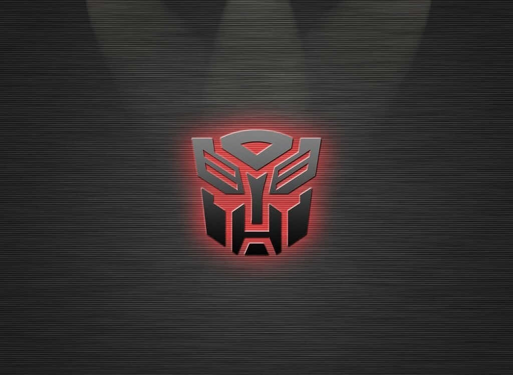 變形金剛 桌布 壁紙 — 一個發光的紅色和銀色 Autobot 標誌，置於帶有微妙光線的深色紋理背景中央。