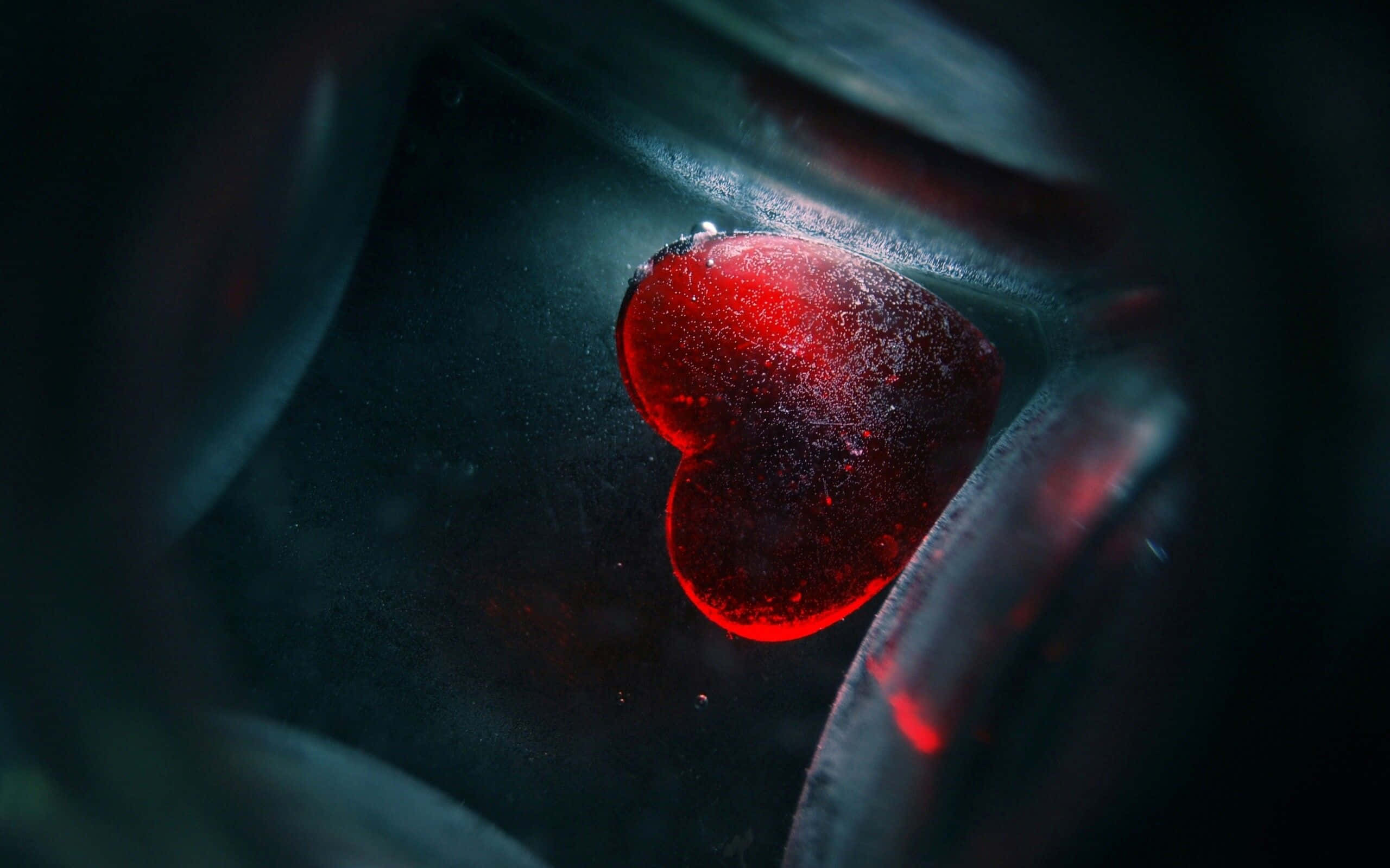 Dark Emotional 桌布 壁紙 — 一個發光的紅色心形物體漂浮在黑暗的水中，周圍有氣泡升起。