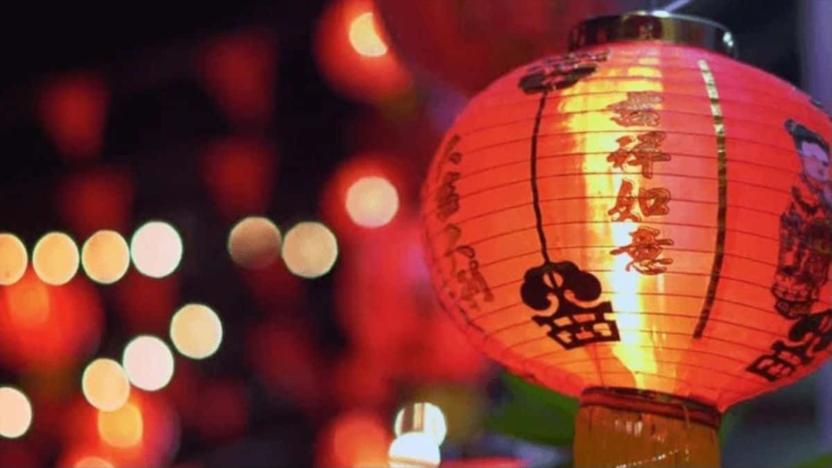 春節 桌布 壁紙 — 一個發光的紅色紙燈籠，上面有中文字和雙喜符號，在夜間節日燈光的散景背景下溫暖地閃耀。