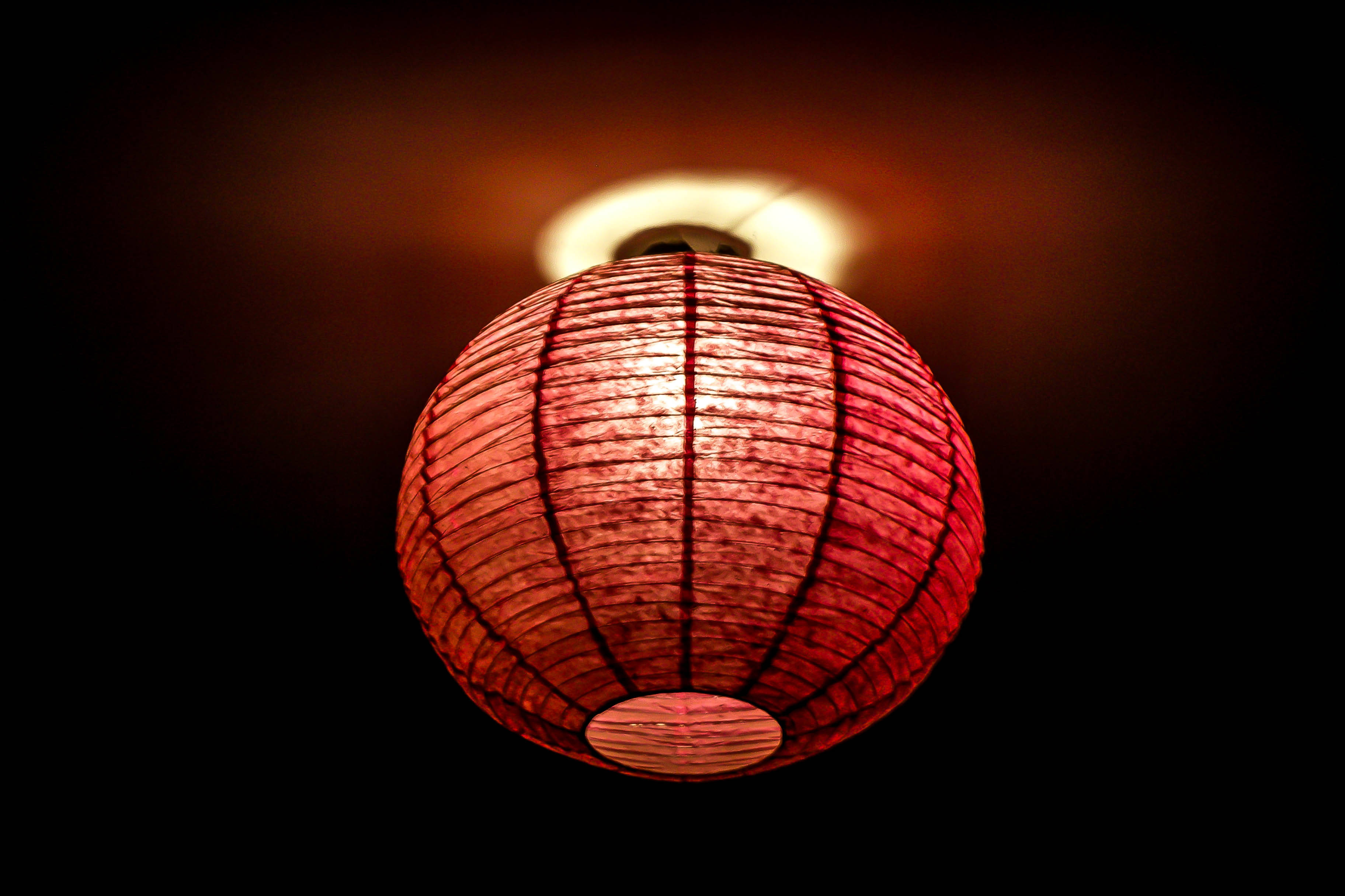 Happy New Year 2021 桌布 壁紙 — 一個發光的紅色紙燈籠懸掛在黑暗的背景上，從內部散發出溫暖的光芒。