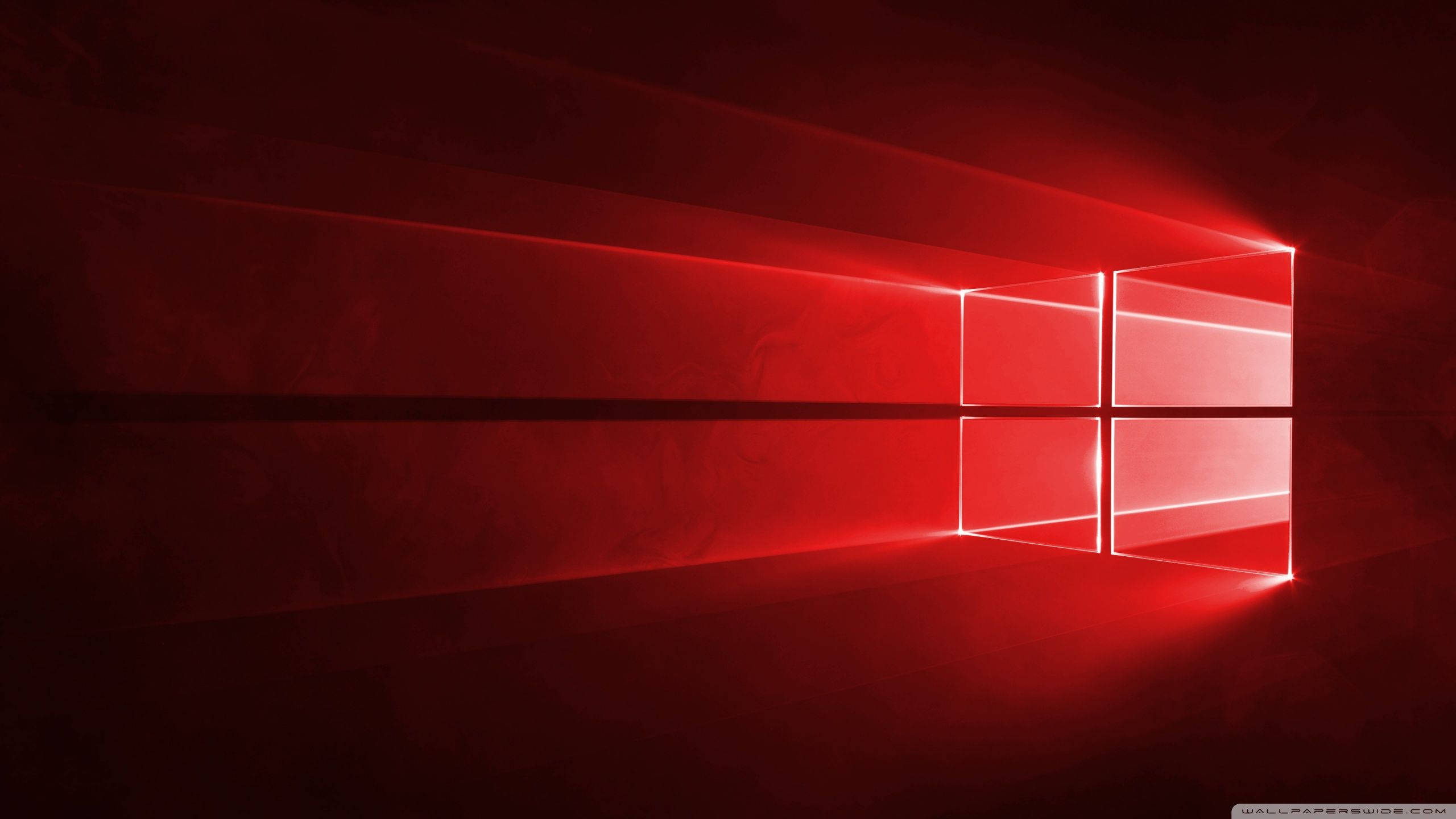 Windows 10 高畫質 桌布 壁紙 — 一個發光的紅色視窗標誌在黑暗紋理表面上投射出耀眼的光束，營造出極簡的數位場景。