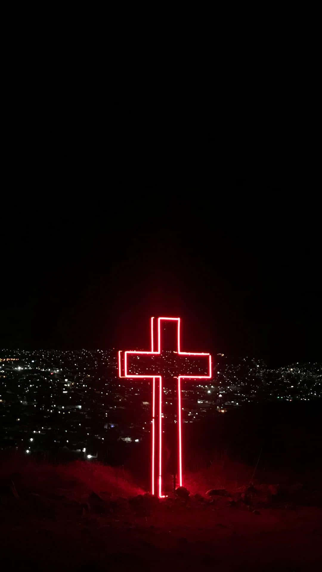 Cute Cross 桌布 壁紙 — 一個發光的紅色霓虹十字架矗立在山頂上，俯瞰著夜晚廣闊的城市景觀。