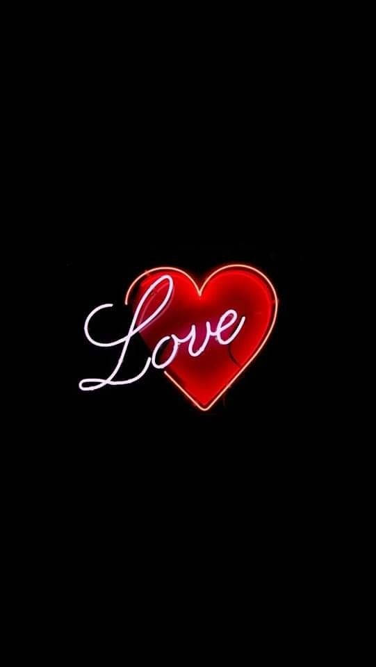 Love Phone 桌布 壁紙 — 一個發光的紅色霓虹心形，帶有草書的「Love」字樣，在純黑色背景上明亮地閃耀。