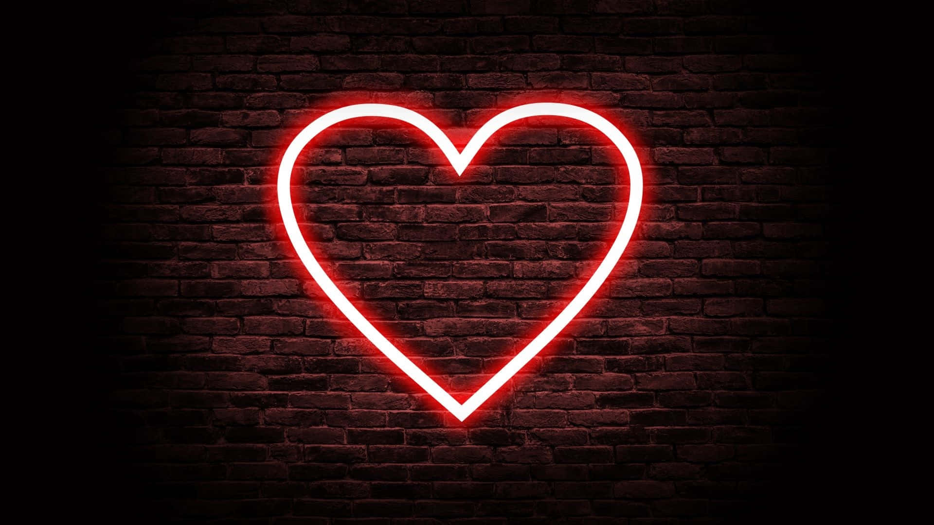Broken Heart Aesthetics 桌布 壁紙 — 一個發光的紅色霓虹心形標誌照亮了深色磚牆，溫暖的光線投射出柔和的陰影。