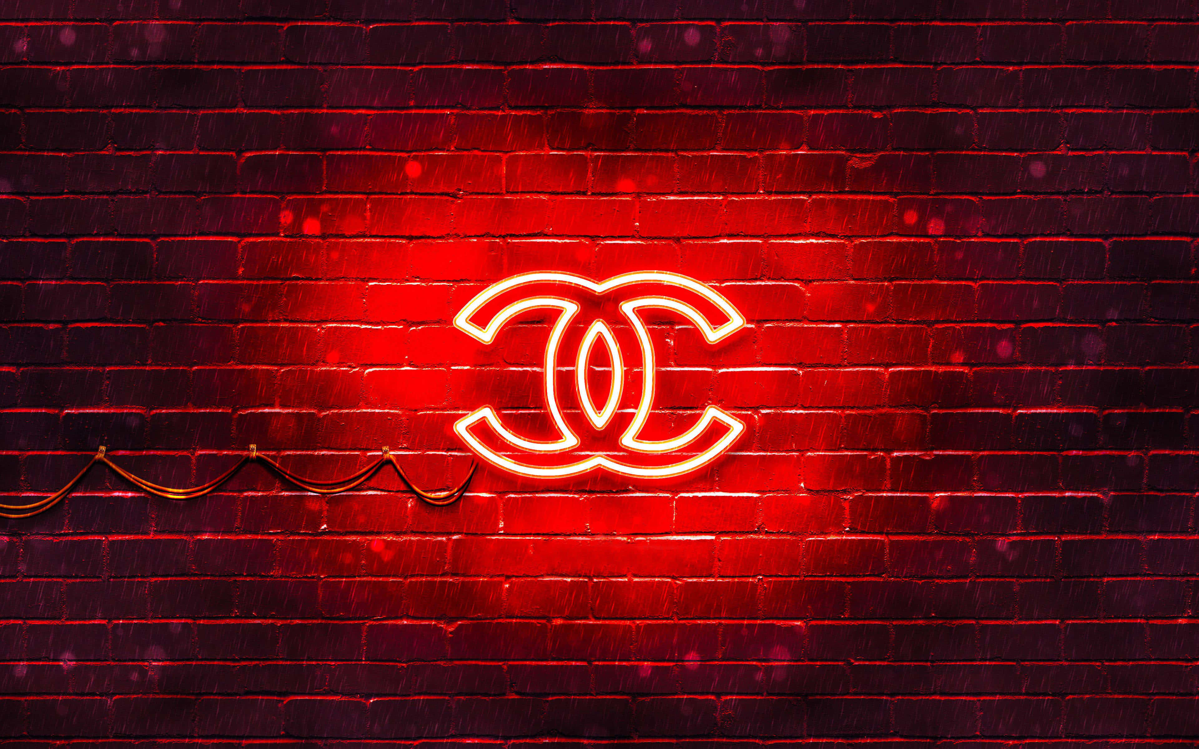 Neon Red Aesthetic 桌布 壁紙 — 一個發光的紅色霓虹燈 Chanel 標誌照亮了深色磚牆，帶有鮮豔的光反射。