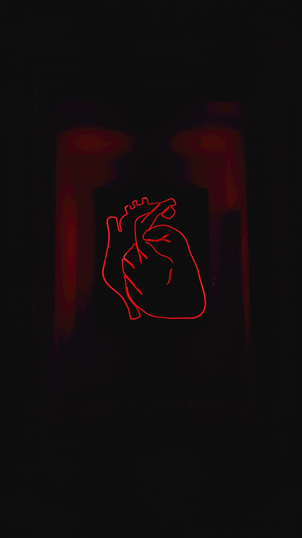 Dark Red Aesthetic 桌布 壁紙 — 一個發光的紅色霓虹燈人體心臟輪廓在黑暗背景上脈動，帶有微弱的紅色環境光。