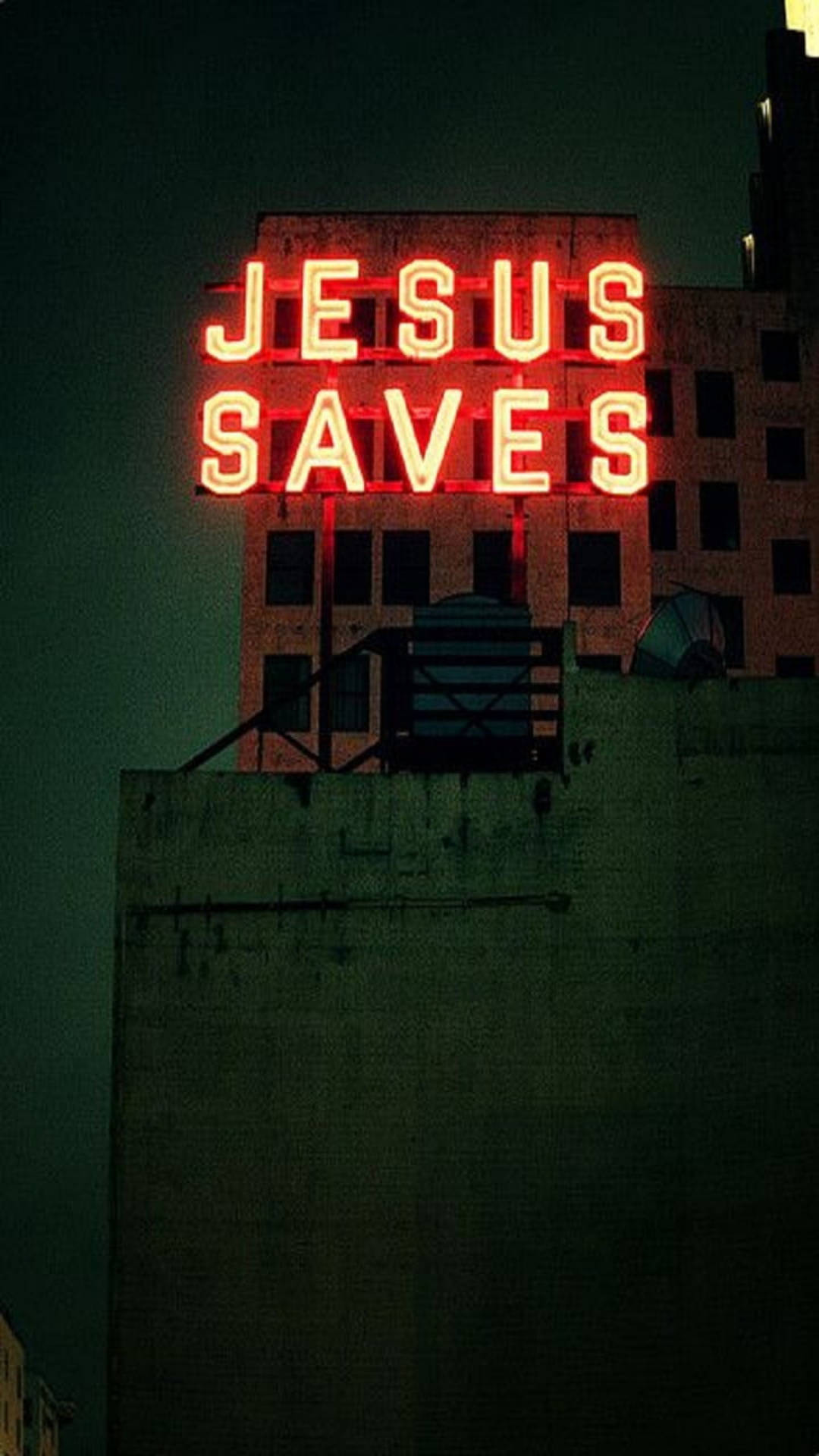 Jesus Christ Quotes 桌布 壁紙 — 一個發光的紅色霓虹燈牌，上面寫著「JESUS SAVES」，照亮了破舊城市建築物頂上的黑暗夜空。