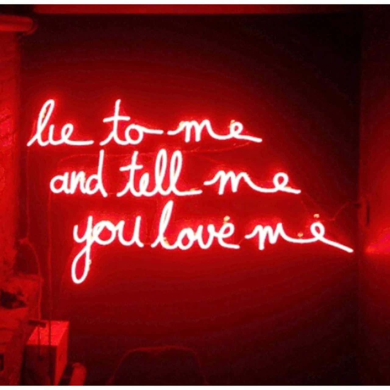 Pastel Red Aesthetic 桌布 壁紙 — 一個發光的紅色霓虹燈牌，以草書字體寫著 lie to me and tell me you love me，背景是深色牆壁。