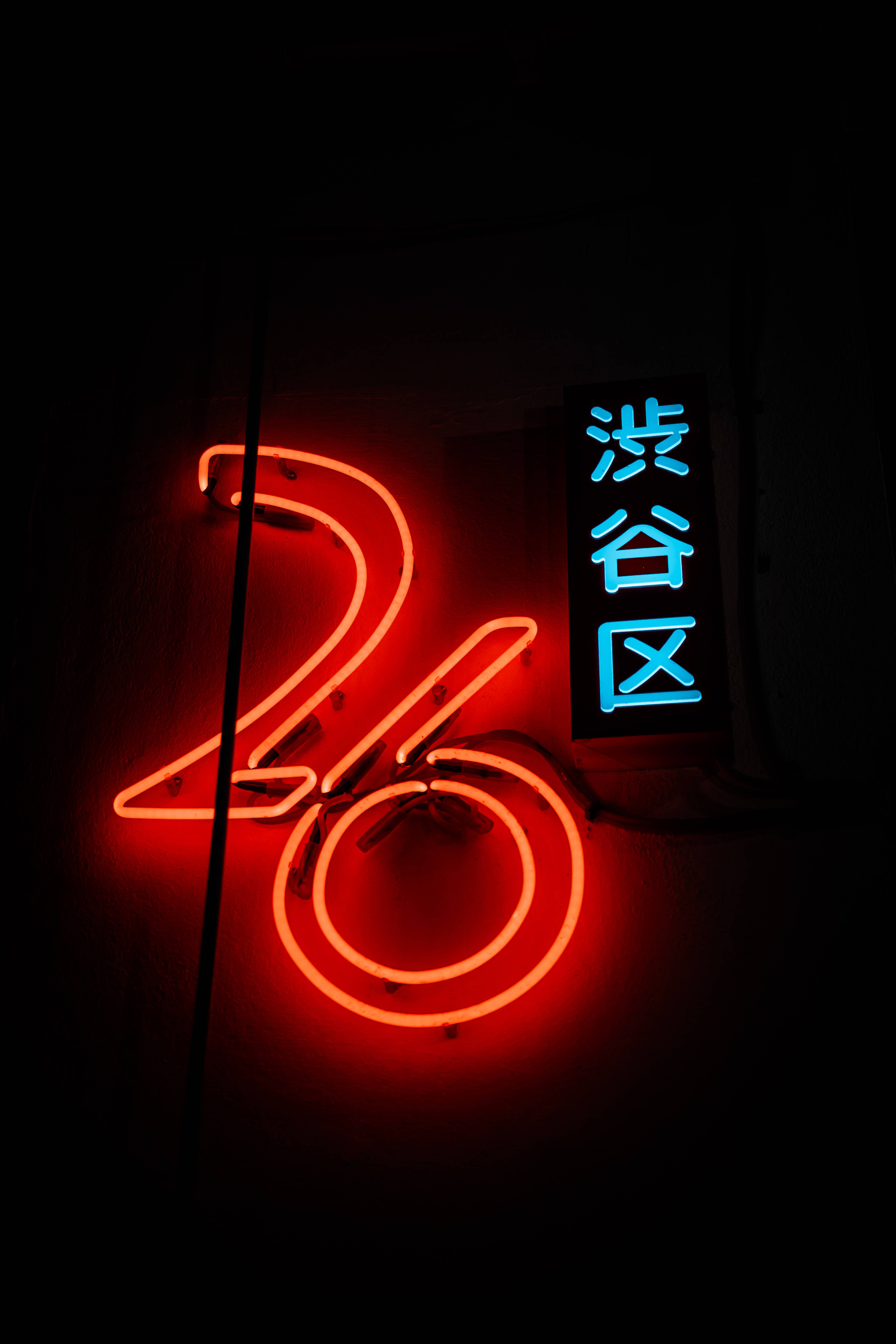 Cyber 桌布 壁紙 — 一個發光的紅色霓虹燈牌，形狀像數字26，旁邊有一個藍色垂直的牌子，上面有日文字，背景是深色牆壁。