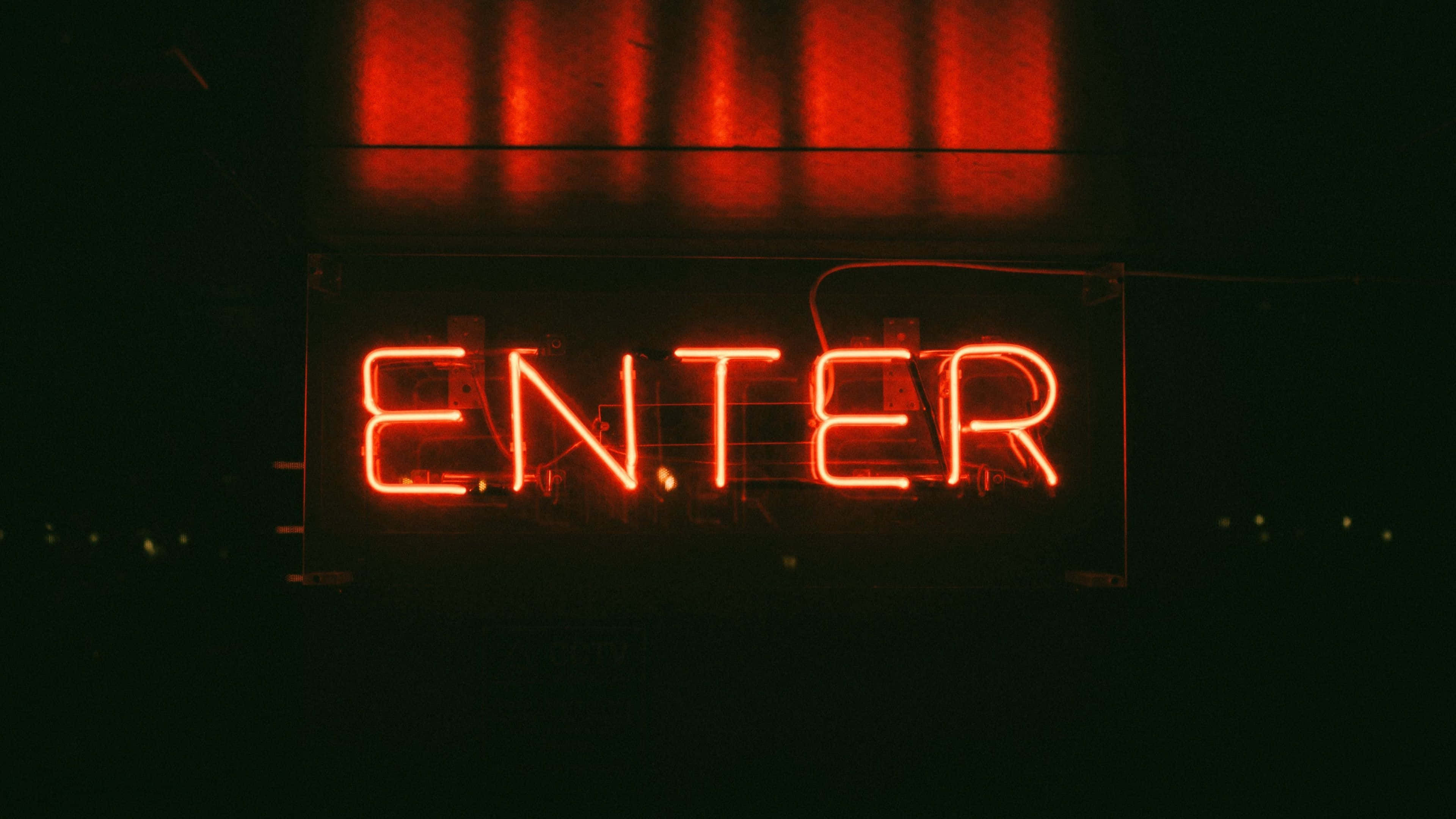 neon sign 桌布 壁紙 — 一個發光的紅色霓虹燈牌，拼寫著ENTER，在黑暗的牆壁上投射出溫暖的光線，上方有垂直的反射。
