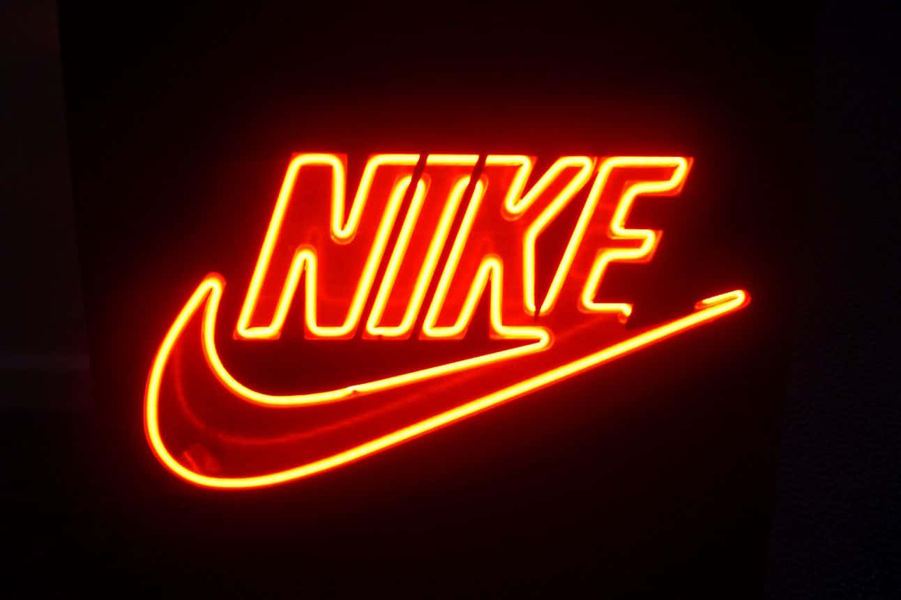紅色動圖 桌布 壁紙 — 一個發光的紅色霓虹燈牌在深色背景上展示Nike標誌。