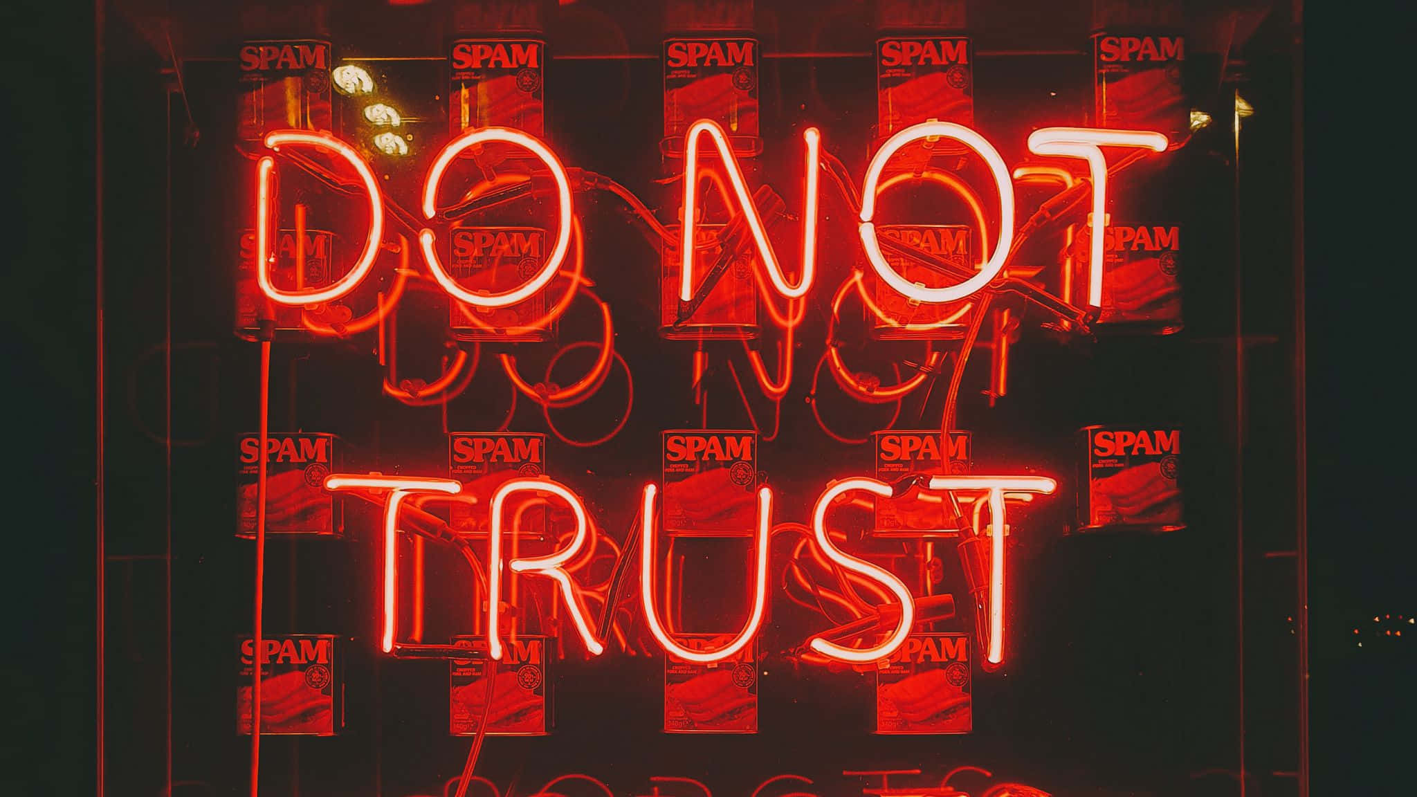 Neon Red Aesthetic 桌布 壁紙 — 一個發光的紅色霓虹燈牌寫著「DO NOT TRUST」，背景是深色並貼滿「SPAM」海報。