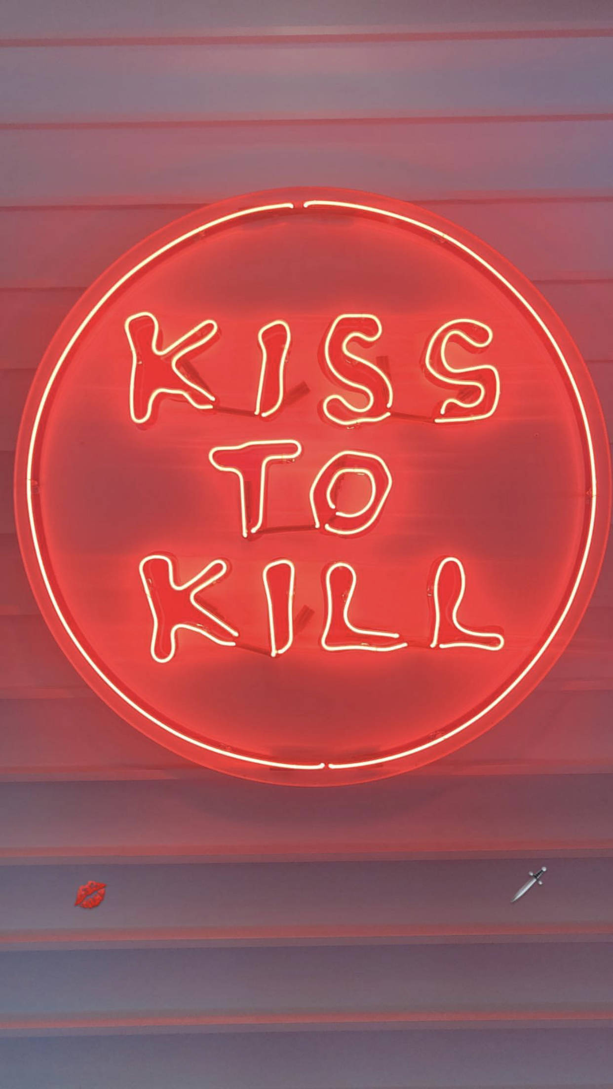 霓虹美學 桌布 壁紙 — 一個發光的紅色霓虹燈牌寫著 kiss to kill，背景是條紋牆，下方有唇印和刀。